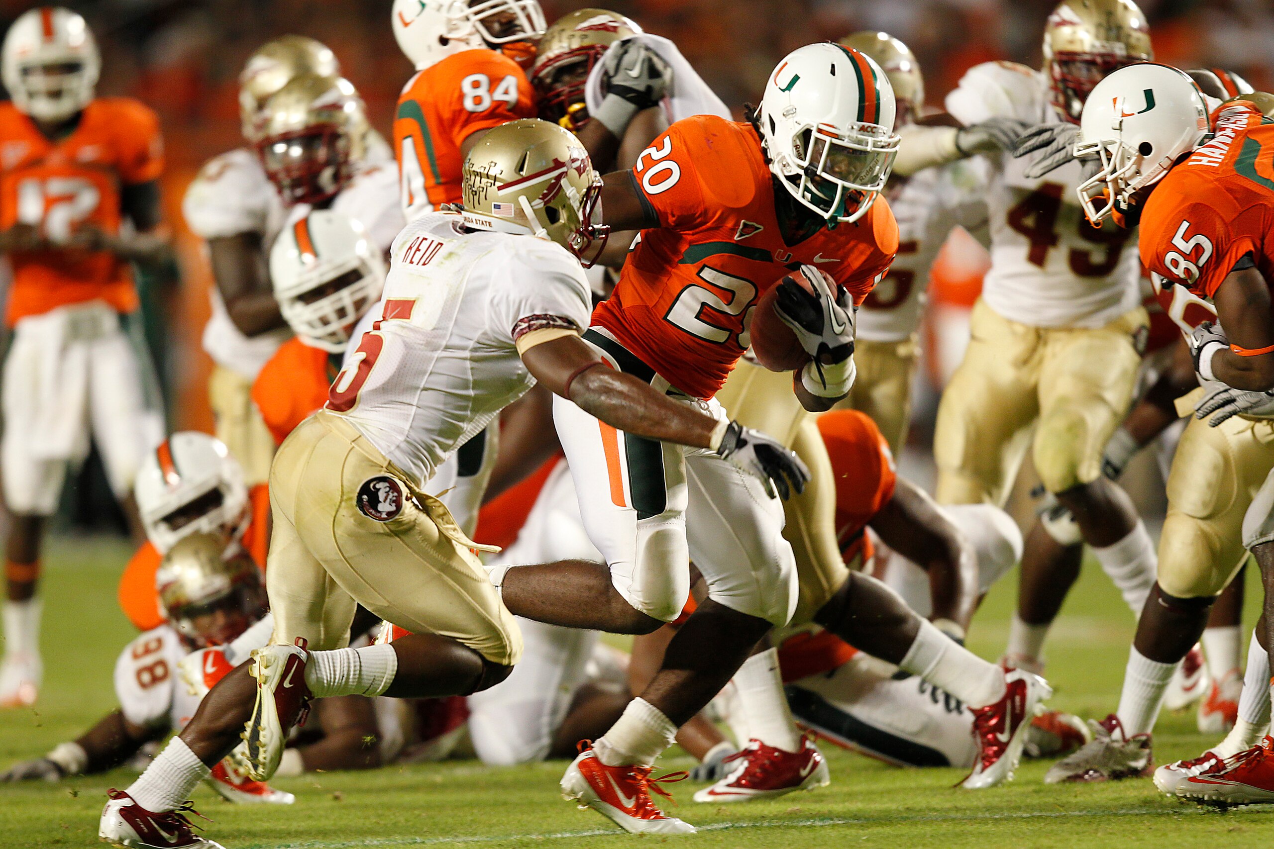 MIAMI, FL - OCTOBER 9: Damien Berry #20 of the Miami Hurricanes breaks the tackle of Greg Reid #5 of the Florida State Seminoles to score a touchdown in the third quarter on October 9, 2010 at Sun Life Stadium in Miami, Florida. The Seminoles defeated the