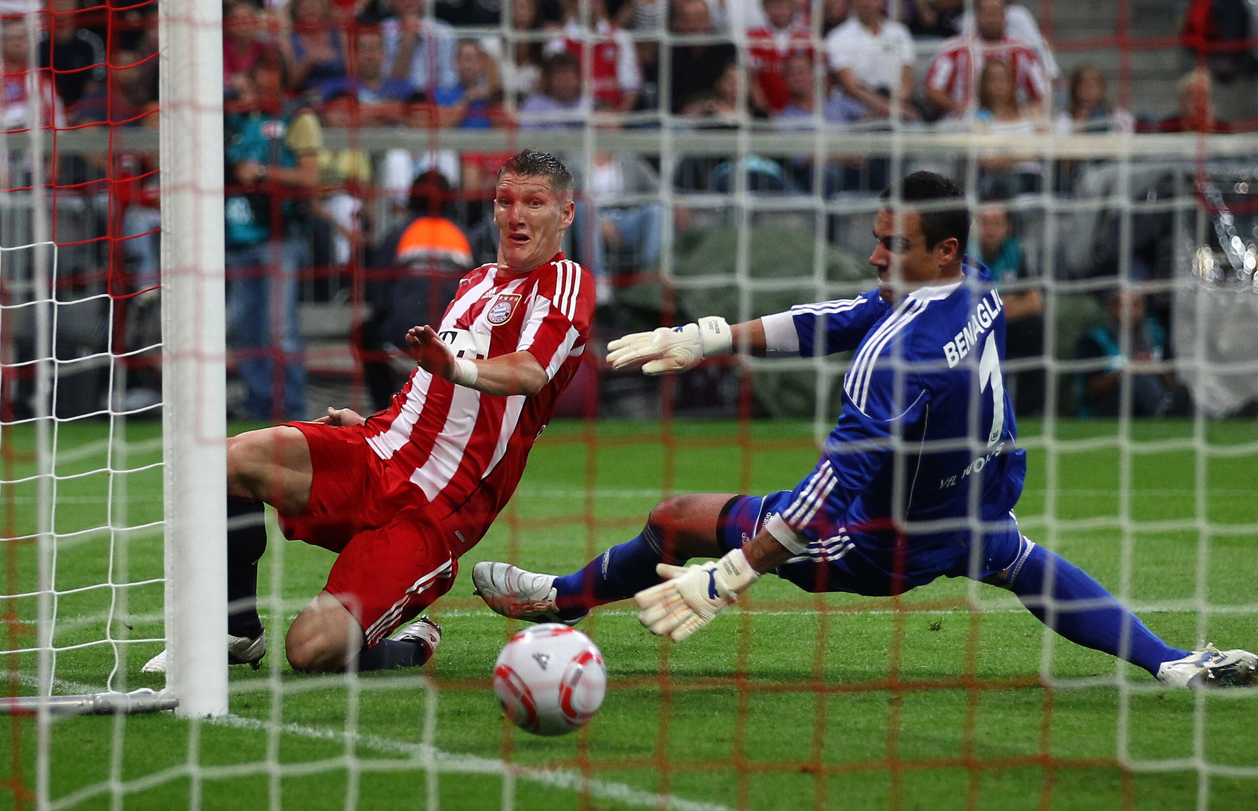 MUNICH, GERMANY - AUGUST 20:  Bastian Schweinsteiger of Bayern scores his team's second and winning goal against goalkeeper Diego Benaglio of Wolfsburg during the Bundesliga match between FC Bayern Muenchen and VfL Wolfsburg at Allianz Arena on August 20,