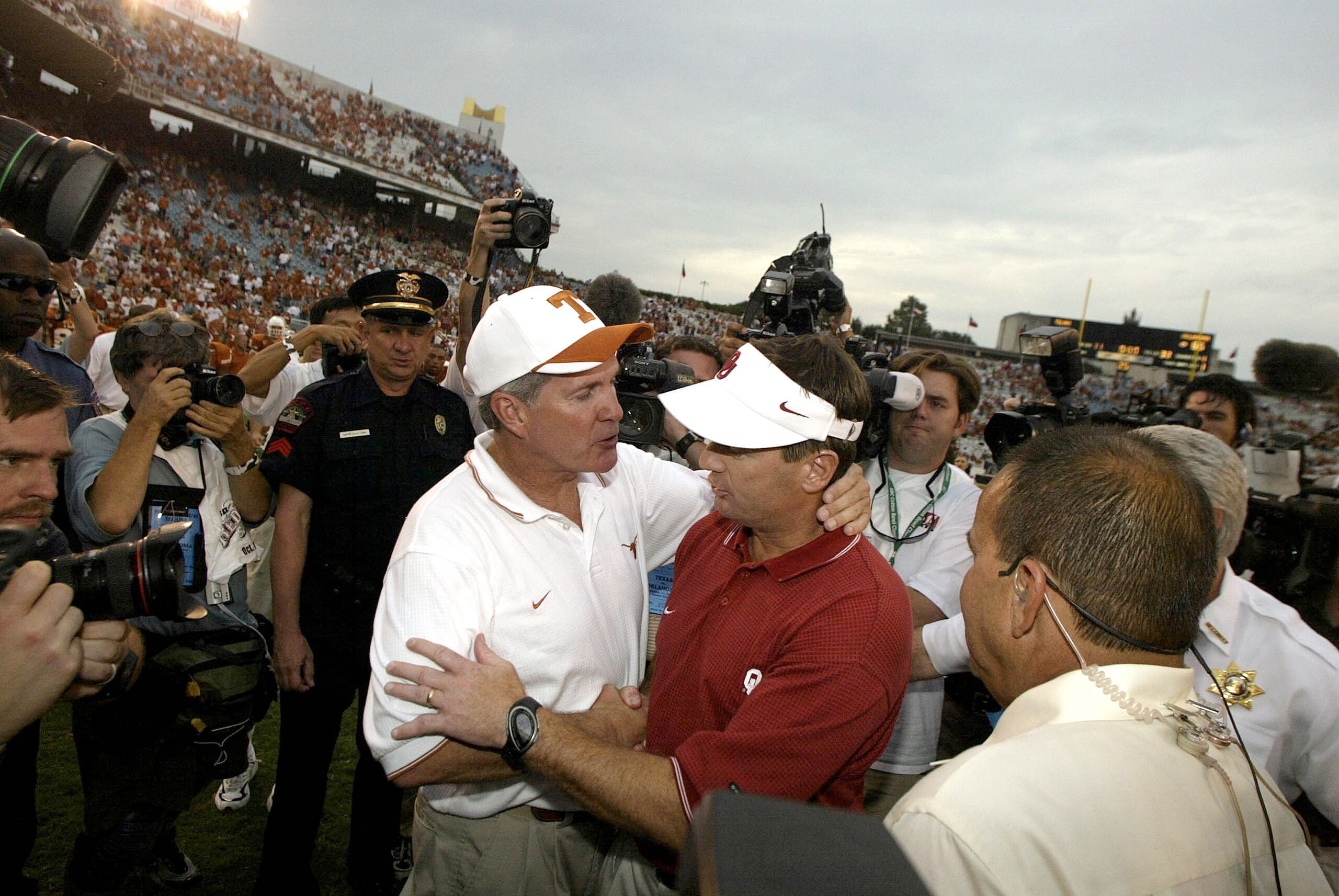 DALLAS - OCTOBER 11:  Head coach Mack Brown of the Texas Longhorns and Bob Stoops of the Oklahoma Sooners greet each other at the end of the game at the Cotton Bowl on October 11, 2003 in Dallas, Texas.  The Sooners defeated the Longhorns 65-13.  (Photo b