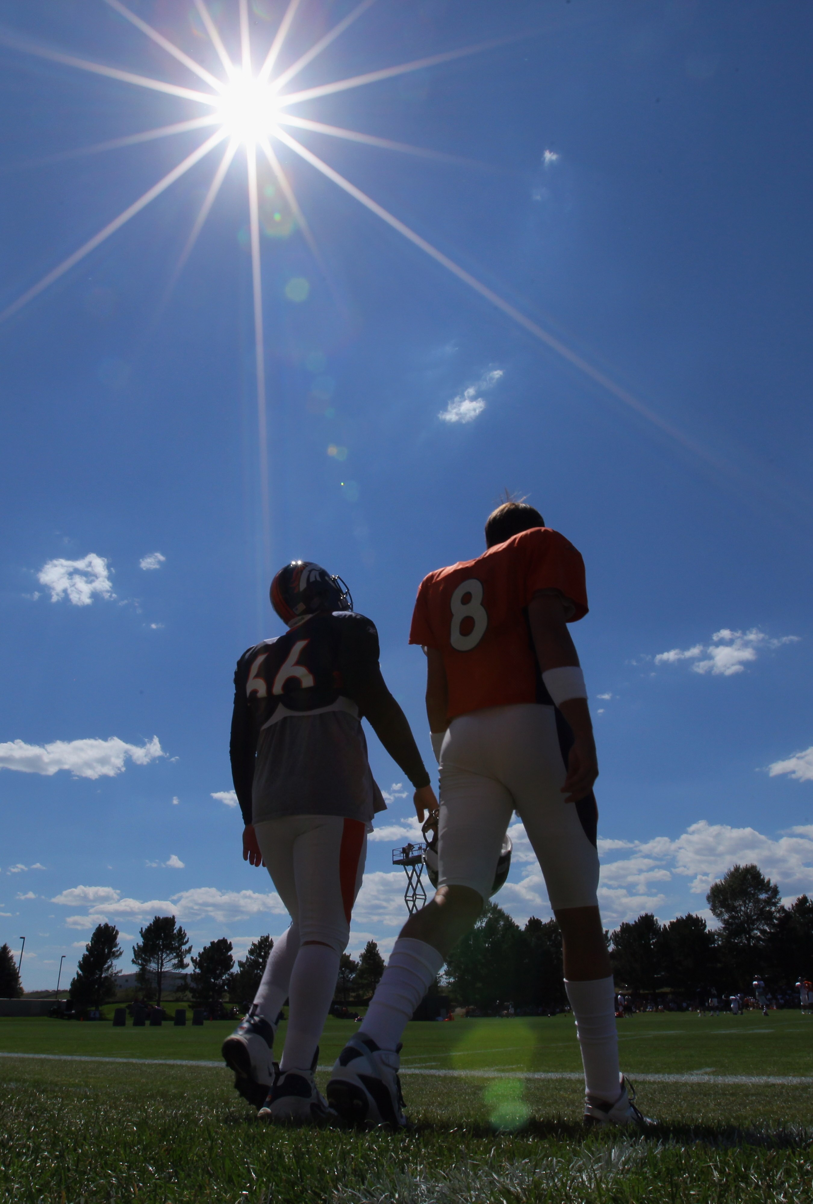 ENGLEWOOD, CO - AUGUST 18:  Quaterback Kyle Orton #8 and long snapper Lonie Paxton #66 of the Denver Broncos head to the field under the midday sun for training camp practice at Dove Valley on August 18, 2010 in Englewood, Colorado. The forecasted record