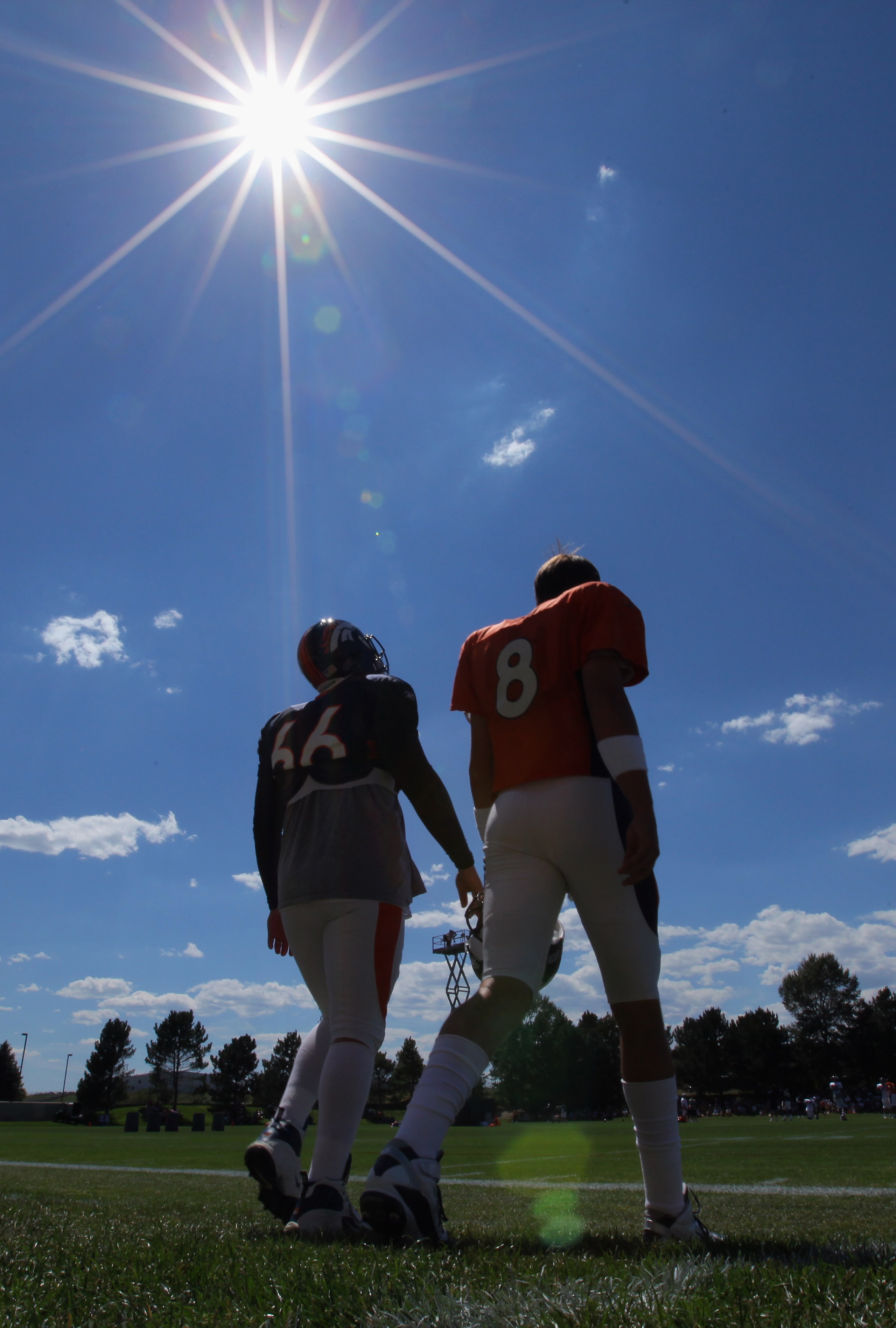ENGLEWOOD, CO - AUGUST 18:  Quaterback Kyle Orton #8 and long snapper Lonie Paxton #66 of the Denver Broncos head to the field under the midday sun for training camp practice at Dove Valley on August 18, 2010 in Englewood, Colorado. The forecasted record