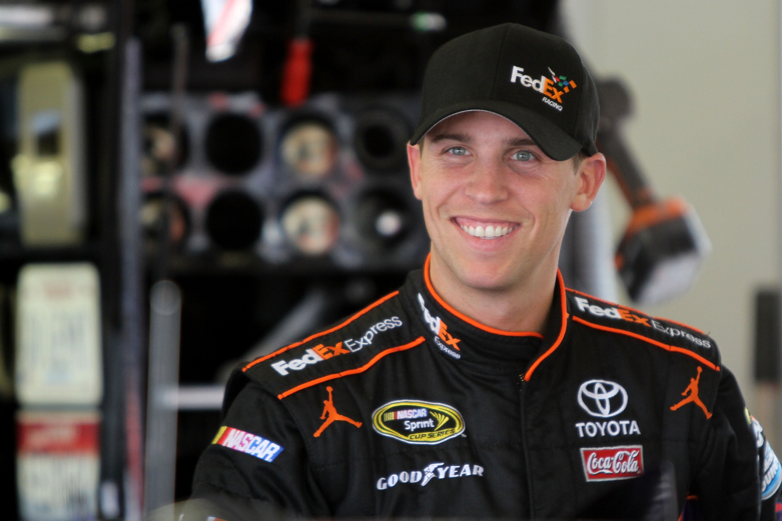 DAYTONA BEACH, FL - FEBRUARY 16:  Denny Hamlin, driver of the #11 FedEx Toyota, looks on in the garage area during practice for the NASCAR Sprint Cup Series Daytona 500 at Daytona International Speedway on February 16, 2011 in Daytona Beach, Florida.  (Ph