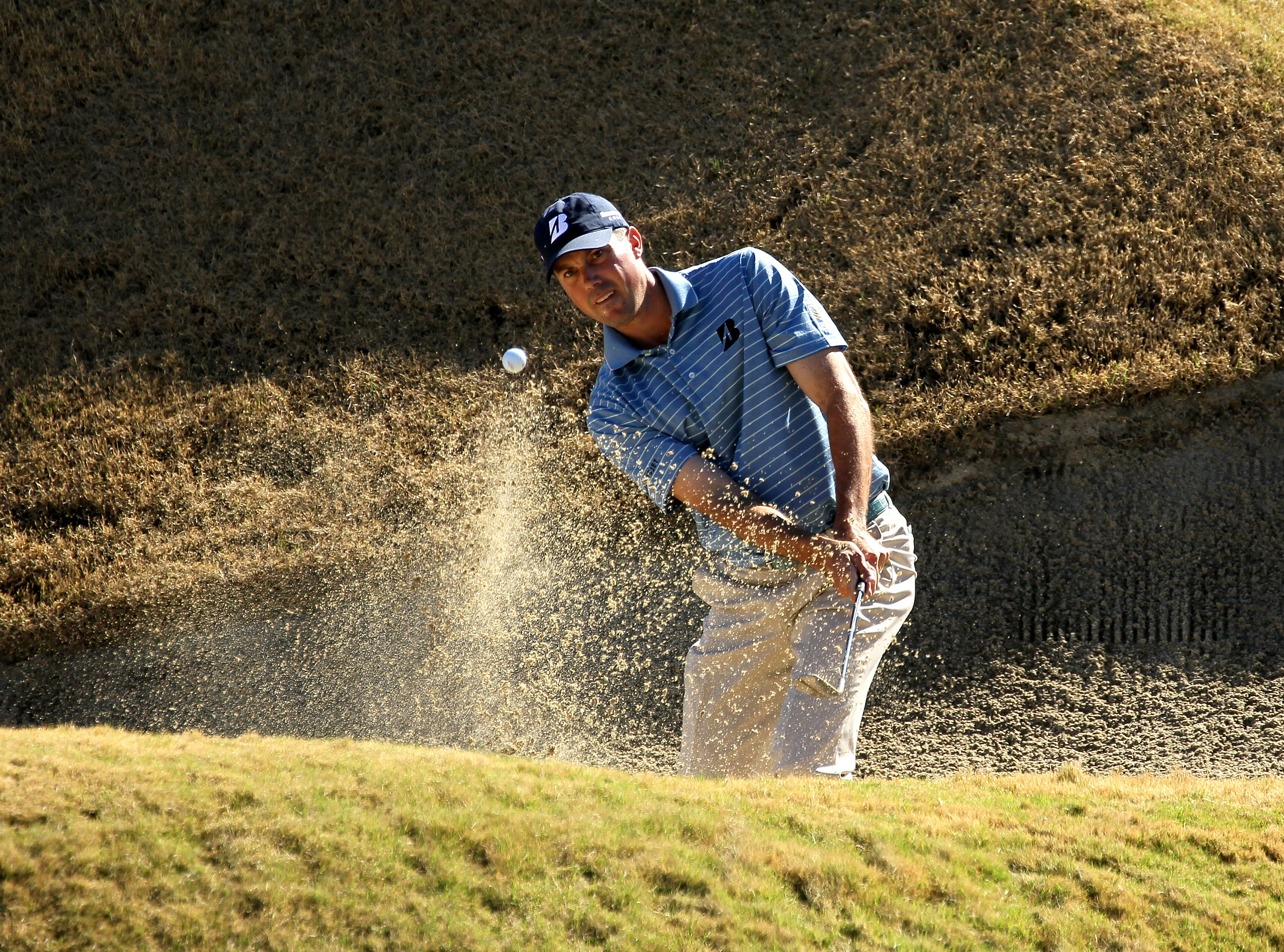 LA QUINTA, CA - JANUARY 21:  Matt Kuchar hits out of a bunker on the 17th hole during round three of the Bob Hope Classic at the Nicklaus Private Course at PGA West on January 21, 2011 in La Quinta, California. (Photo by Stephen Dunn/Getty Images)