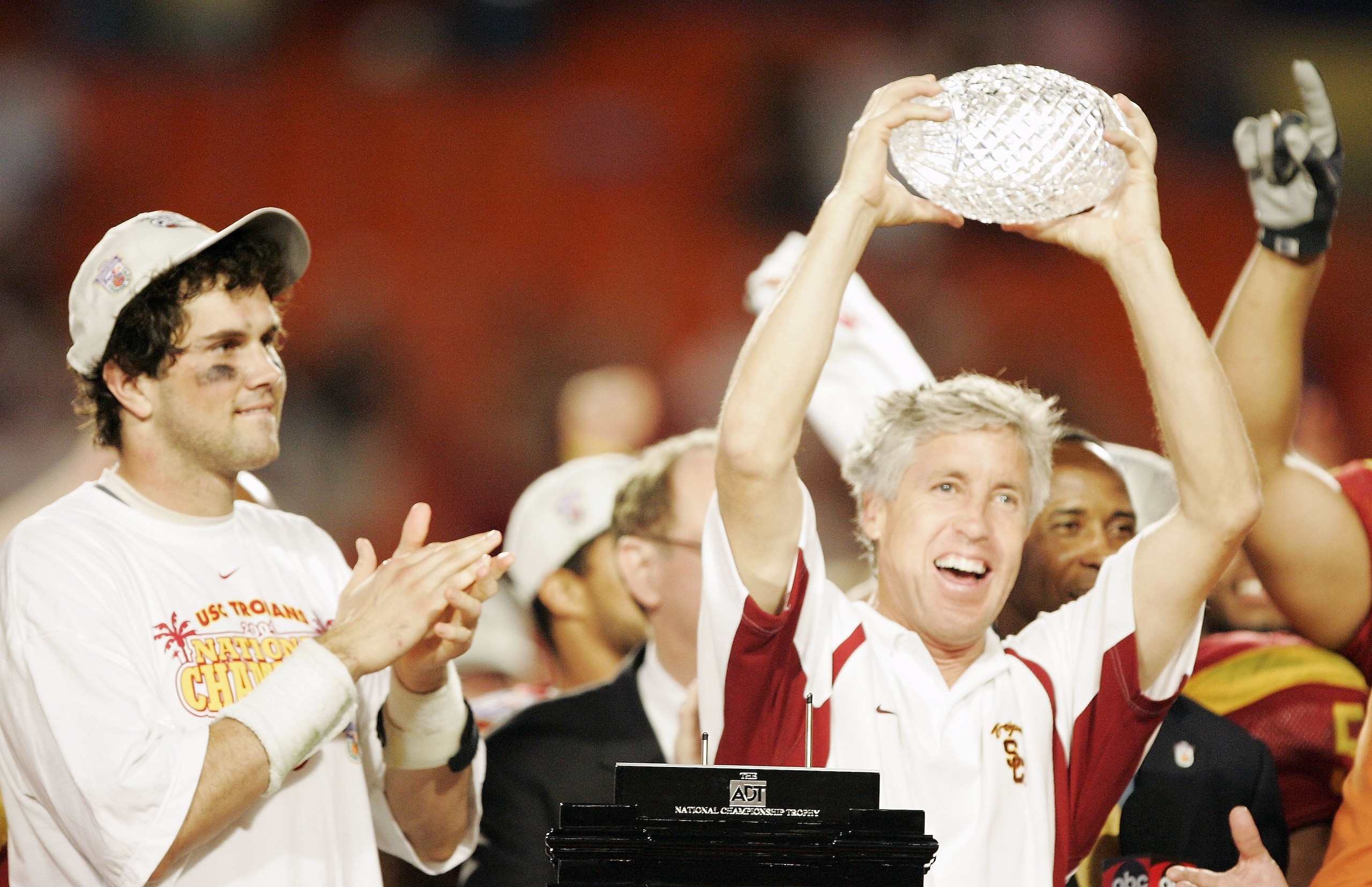 MIAMI - JANUARY 4:  Head coach Pete Carroll of the USC Trojans holds up the championship trophy as quarterback Matt Leinart #11 celebrates after defeating the Oklahoma Sooners 55-19 to win the FedEx Orange Bowl 2005 National Championship on January 4, 200