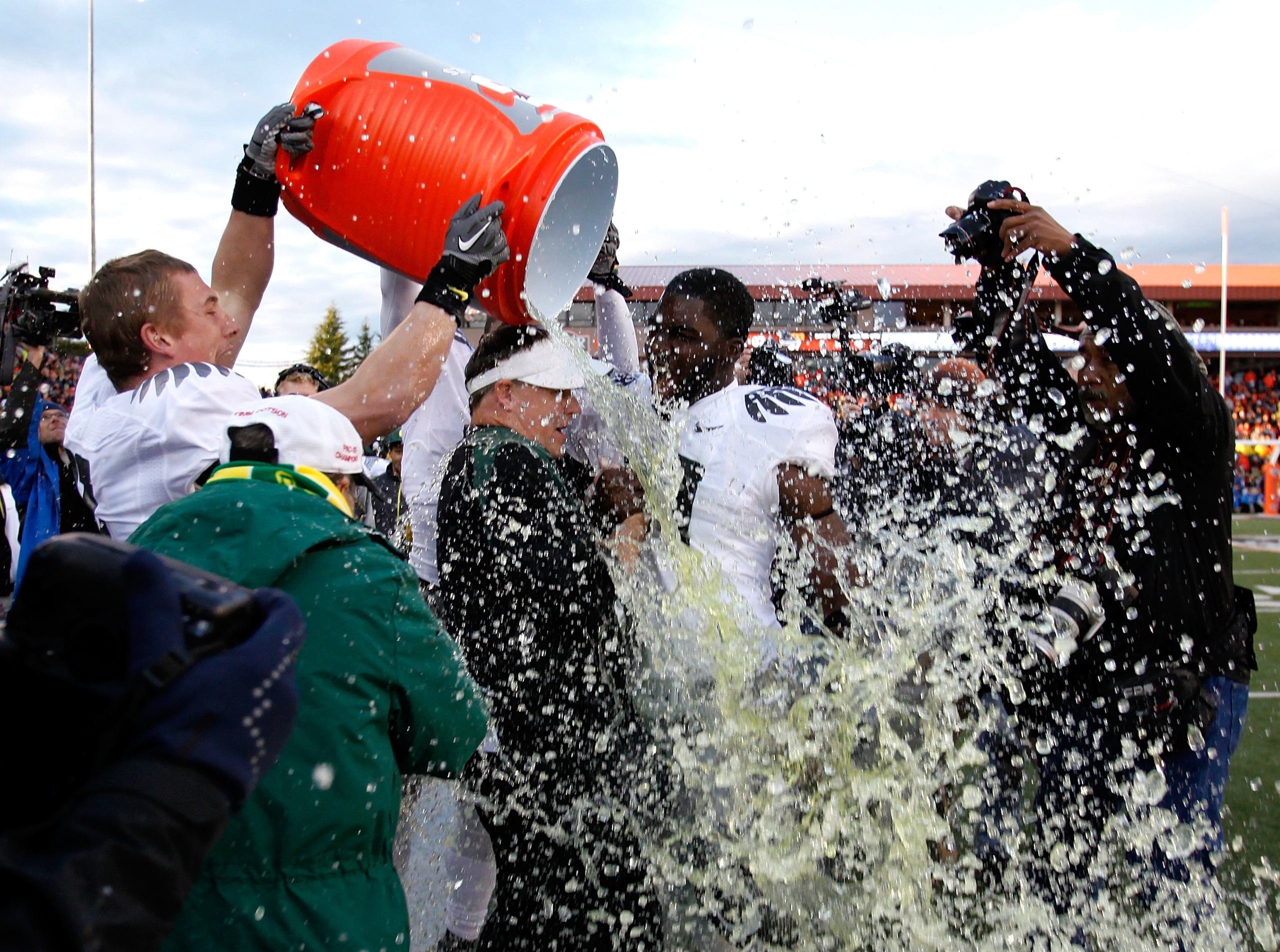 CORVALLIS, OR - DECEMBER 04:  Head Coach Chip Kelly of the Oregon Ducks laughs with Drew Davis #10 after having Gatorade dumped on him after the 37-20 victory over the Oregon State Beavers during the 114th Civil War on December 4, 2010 at the Reser Stadiu