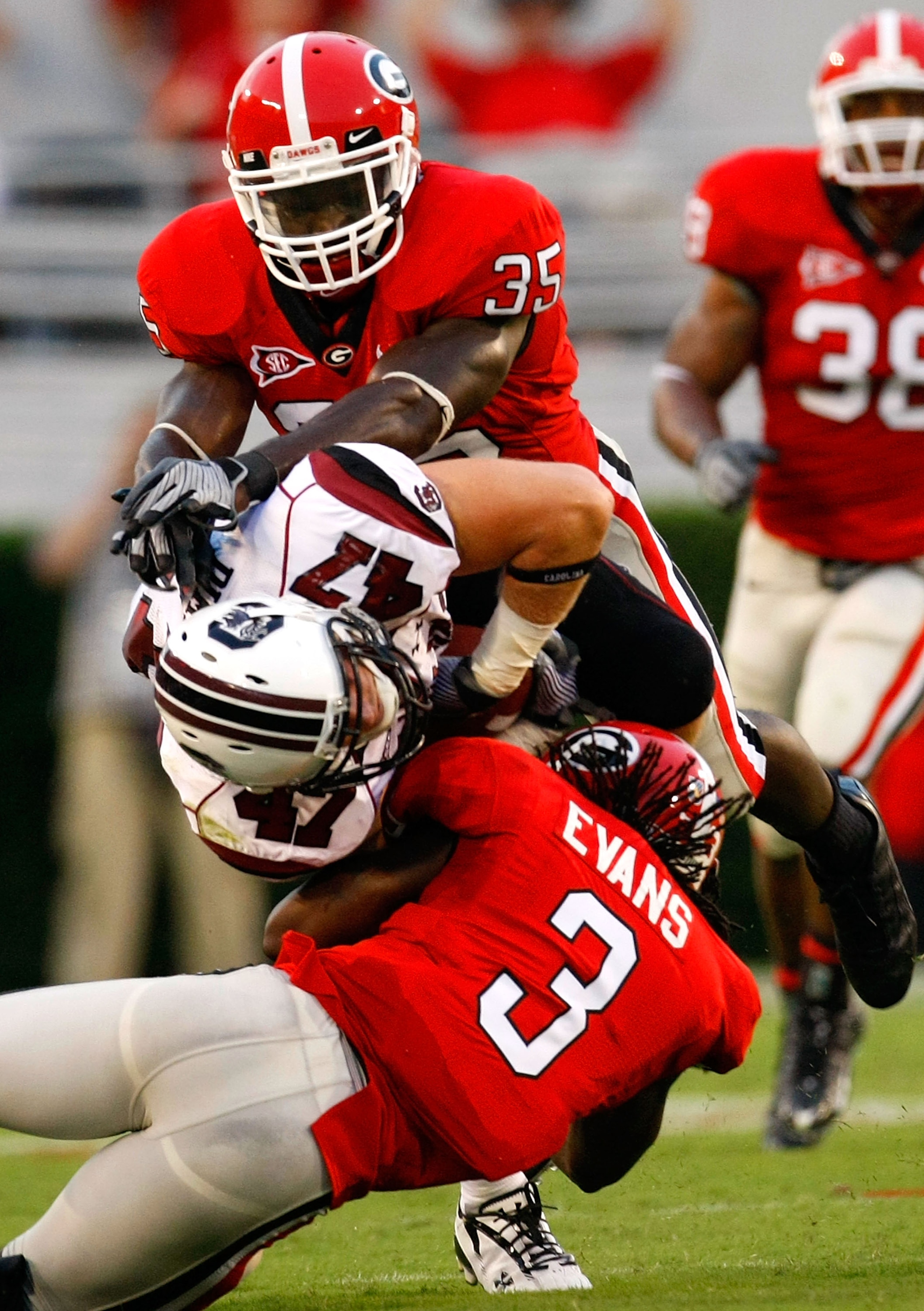 ATHENS, GA - SEPTEMBER 12:  Rennie Curran #35 and Bryan Evans #3 of the Georgia Bulldogs tackle Patrick DiMarco #47 of the South Carolina Gamecocks at Sanford Stadium on September 12, 2009 in Athens, Georgia.  (Photo by Kevin C. Cox/Getty Images)