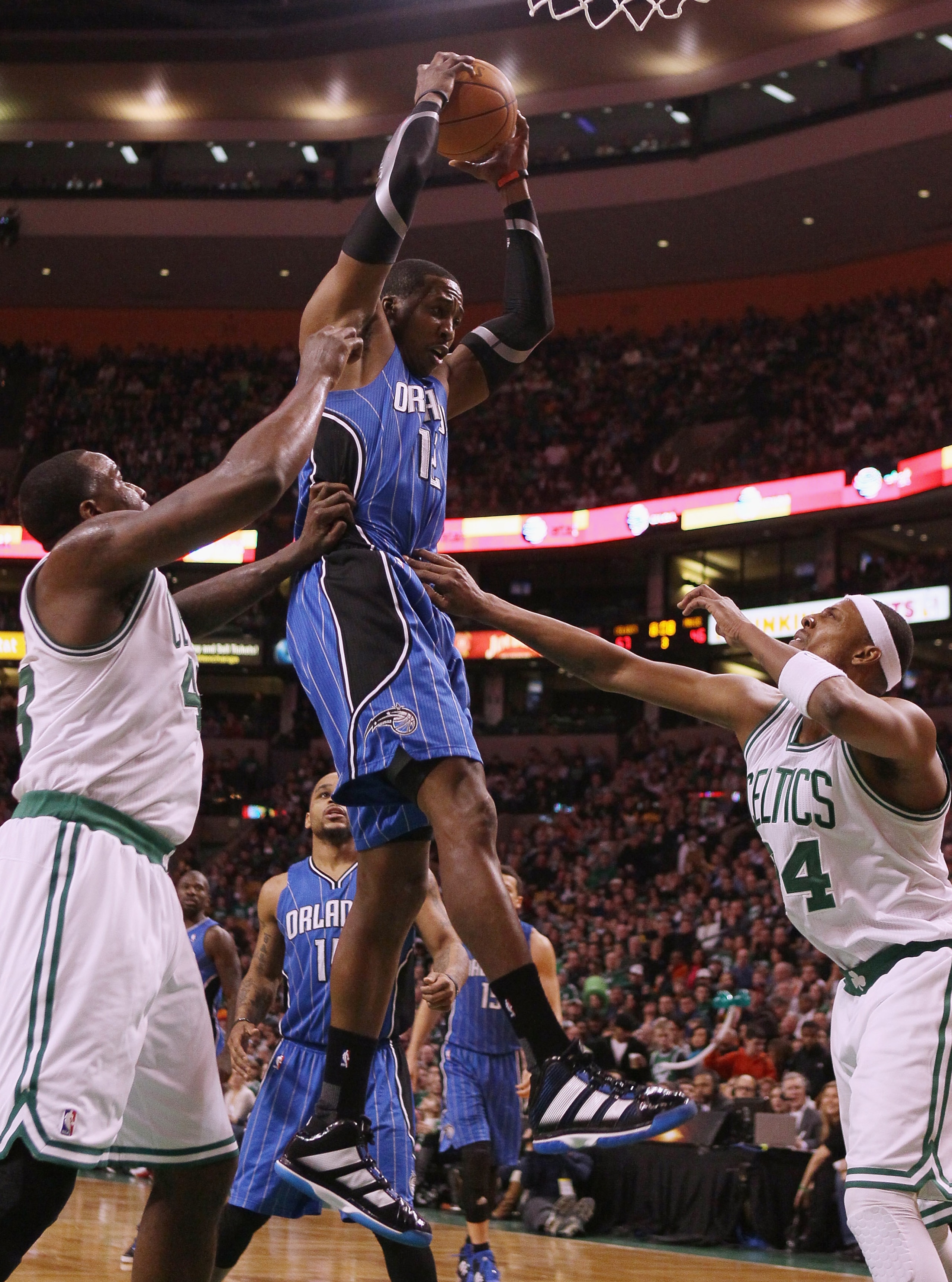 BOSTON, MA - FEBRUARY 06:  Dwight Howard #12 of the Orlando Magic grabs the rebound before Kendrick Perkins #43 and Paul Pierce #34 of the Boston Celtics on February 6, 2011 at the TD Garden in Boston, Massachusetts. The Celtics defeated the Magic 91-80.