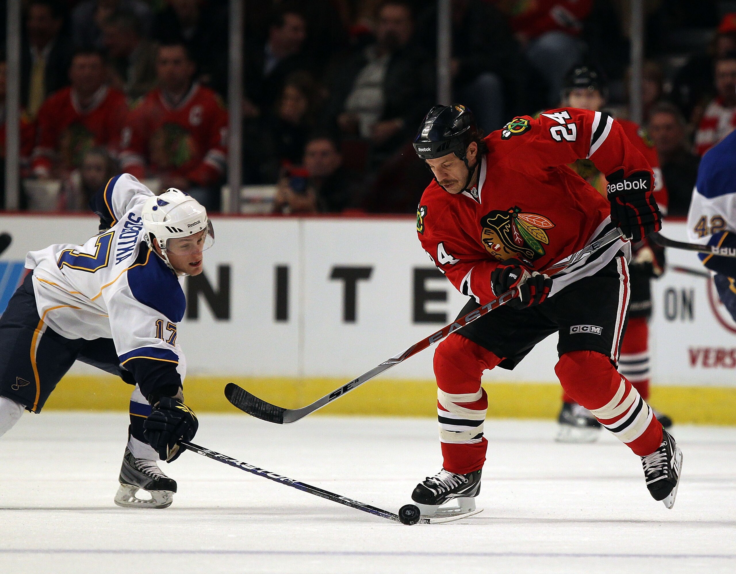 CHICAGO, IL - NOVEMBER 30: Nick Boynton #24 of the Chicago Blackhawks tries to control the puck under pressure from Vladimir Sobotka #17 of the St. Louis Blues at the United Center on November 30, 2010 in Chicago, Illinois. The Blackhawks defeated the Blu