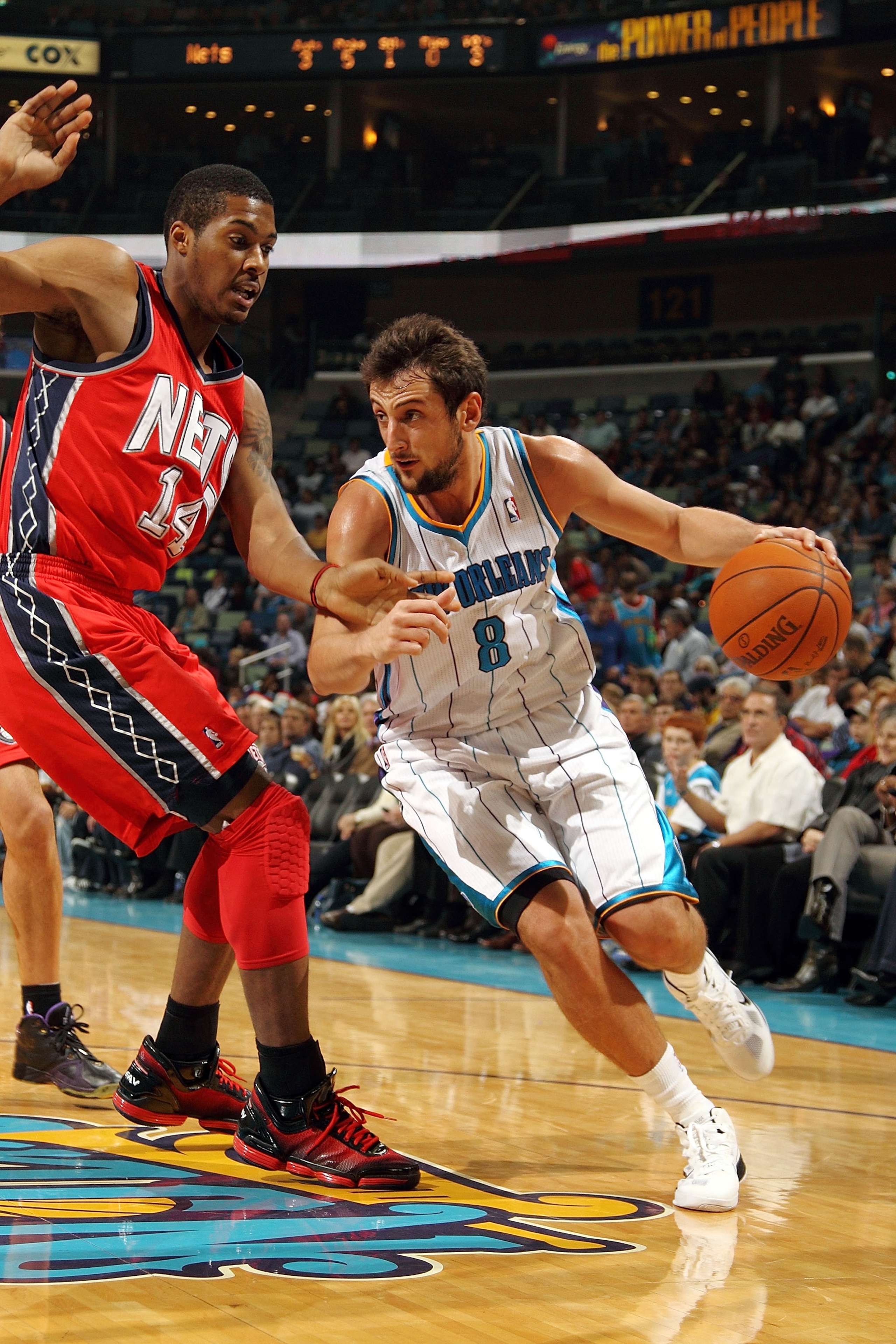 NEW ORLEANS, LA - DECEMBER 22:  Marco Belinelli #8 of the New Orleans Hornets drives the ball around Derrick Favors #14 of the New Jersey Nets at the New Orleans Arena on December 22, 2010 in New Orleans, Louisiana.  The Hornets defeated the Nets 105-91.