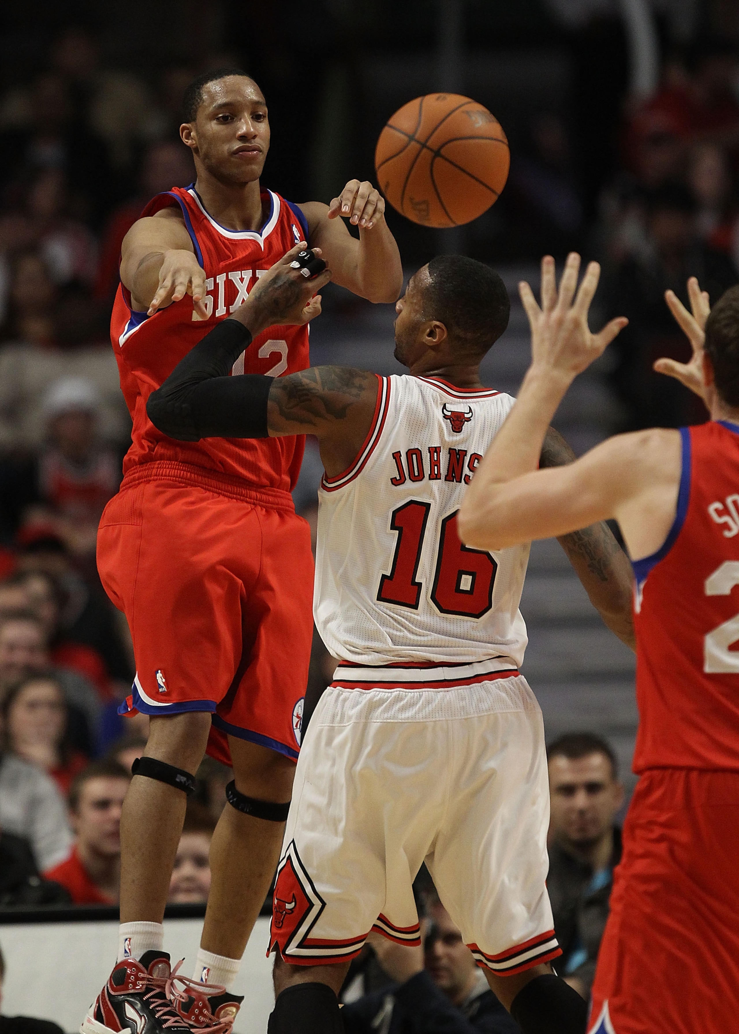 CHICAGO, IL - DECEMBER 21: Evan Turner #12 of the Philadelphia 76ers jumps to pass the ball over James Johnson #16 of the Chicago Bulls at the United Center on December 21, 2010 in Chicago, Illinois. The Bulls defeated the 76ers 121-76. NOTE TO USER: User CHICAGO, IL - DECEMBER 21: Evan Turner #12 of the Philadelphia 76ers jumps to pass the ball over James Johnson #16 of the Chicago Bulls at the United Center on December 21, 2010 in Chicago, Illinois. The Bulls defeated the 76ers 121-76. NOTE TO USER: User