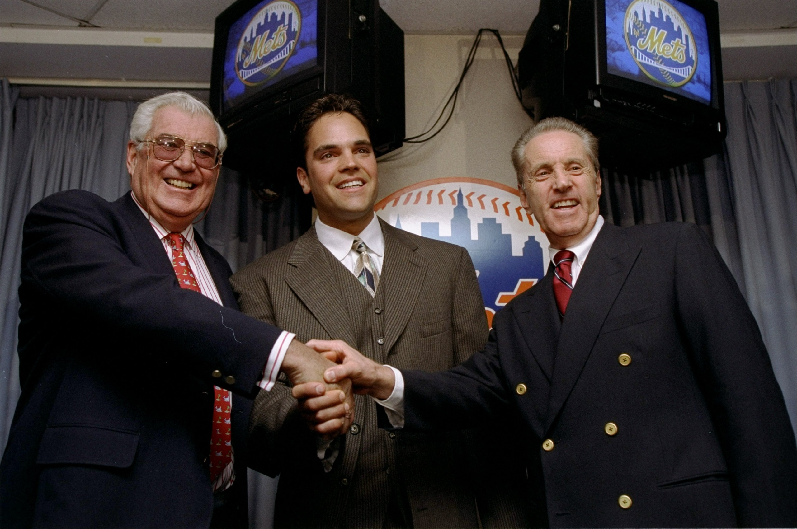 26 Oct 1998: Mike Piazza of the New York Mets shakes hands with Mets Owners Fred Wilpon (R) and Nelson Doubleday (L) during a Press Conference in New York City, New York. Mandatory Credit: Jamie Squire /Allsport 26 Oct 1998: Mike Piazza of the New York Mets shakes hands with Mets Owners Fred Wilpon (R) and Nelson Doubleday (L) during a Press Conference in New York City, New York. Mandatory Credit: Jamie Squire /Allsport