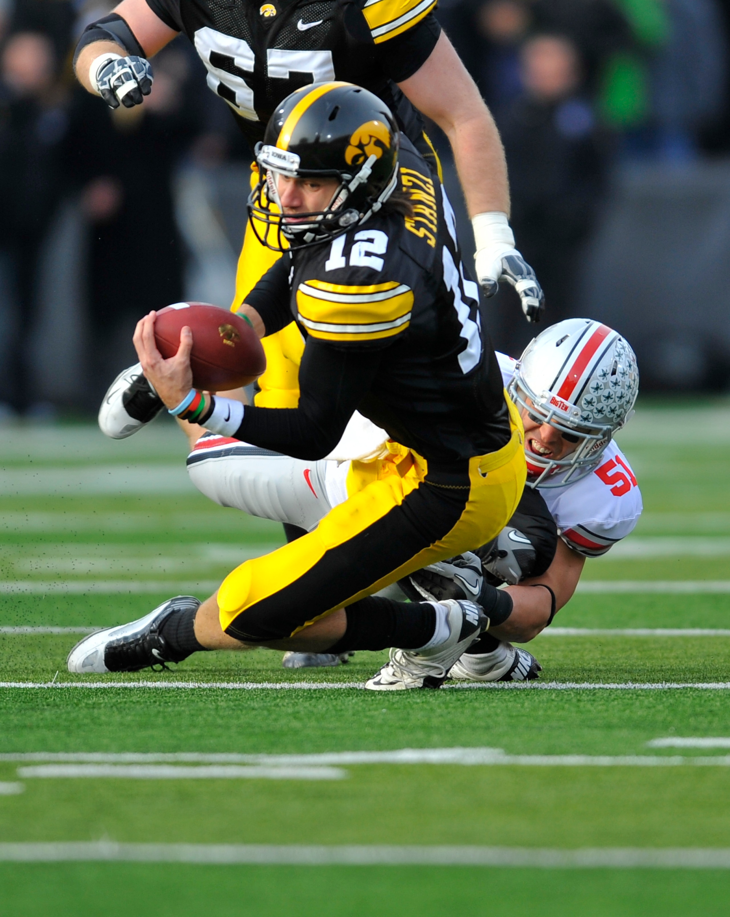 IOWA CITY, IA - NOVEMBER 20:  Quarterback Ricky Stanzi #12 of the University of Iowa Hawkeyes scrambles for yards as linebacker Ross Homan #51 of the Ohio State Buckeyes defends during the first half of play at Kinnick Stadium on November 20, 2010 in Iowa