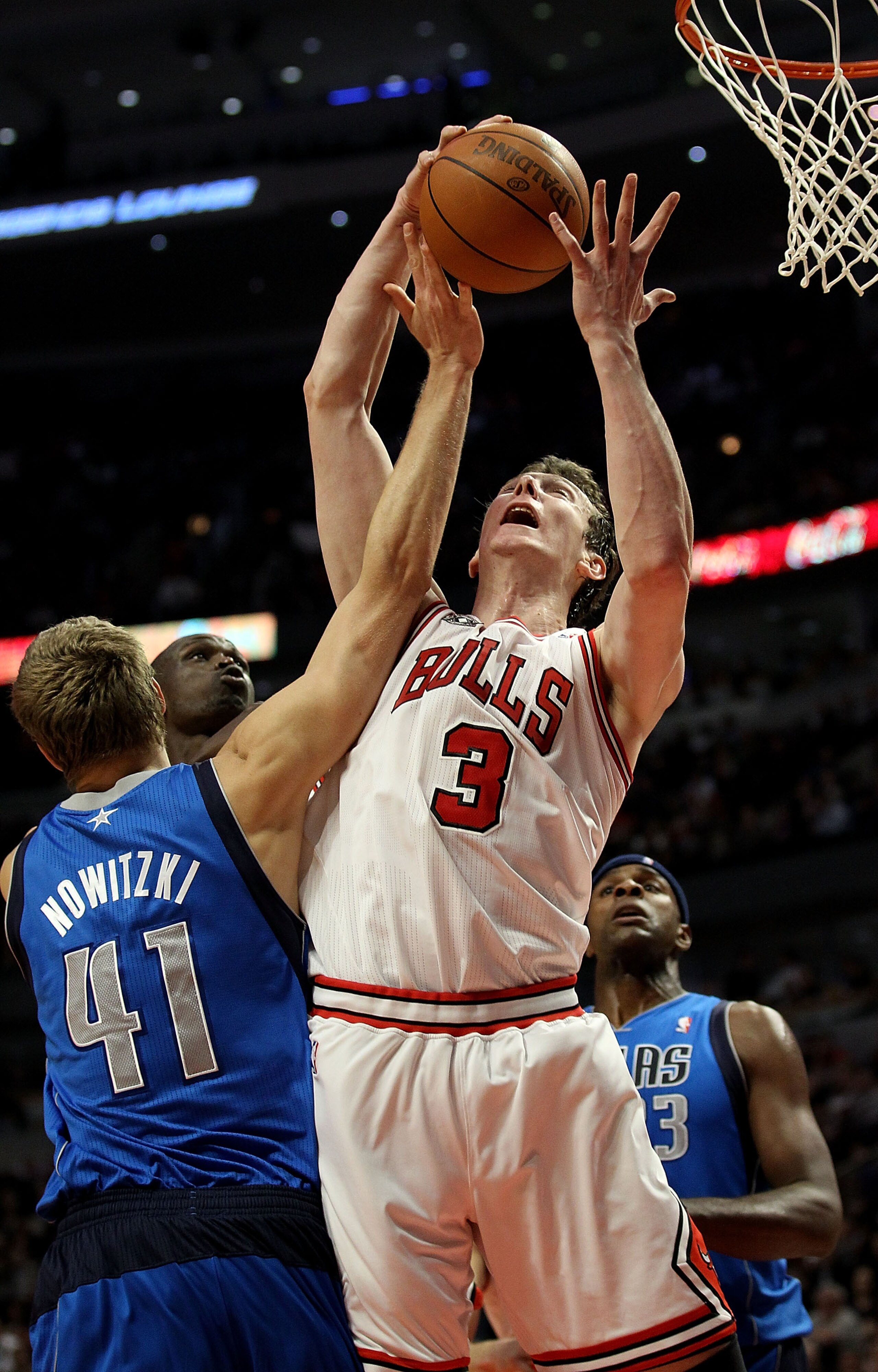 CHICAGO, IL - JANUARY 20: Omer Asik #3 of the Chicago Bulls grabs a rebound over Dirk Nowitzki #41 of the Dallas Mavericks at the United Center on January 20, 2011 in Chicago, Illinois. NOTE TO USER: User expressly acknowledges and agrees that, by downloa