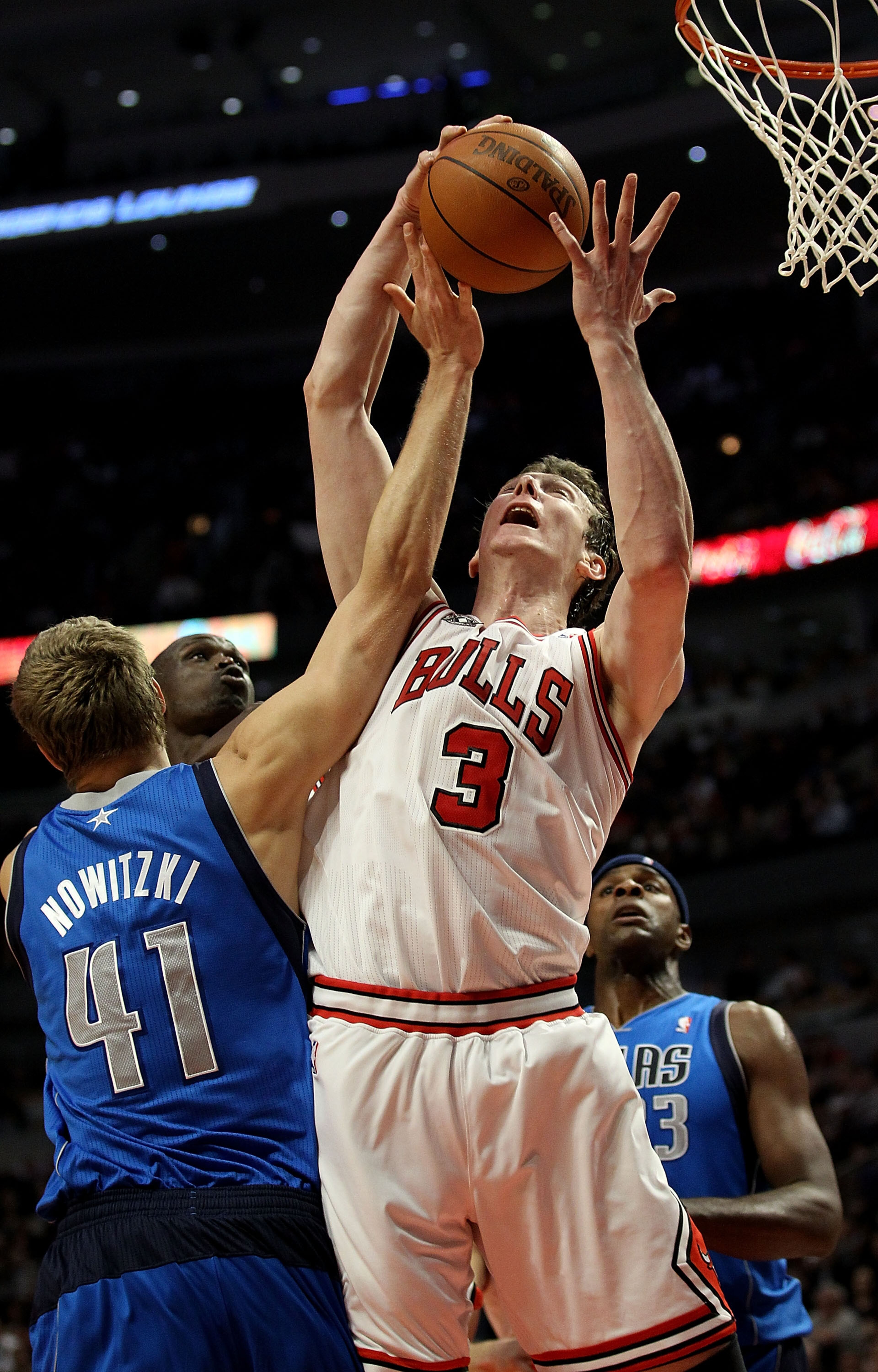 CHICAGO, IL - JANUARY 20: Omer Asik #3 of the Chicago Bulls grabs a rebound over Dirk Nowitzki #41 of the Dallas Mavericks at the United Center on January 20, 2011 in Chicago, Illinois. NOTE TO USER: User expressly acknowledges and agrees that, by downloa