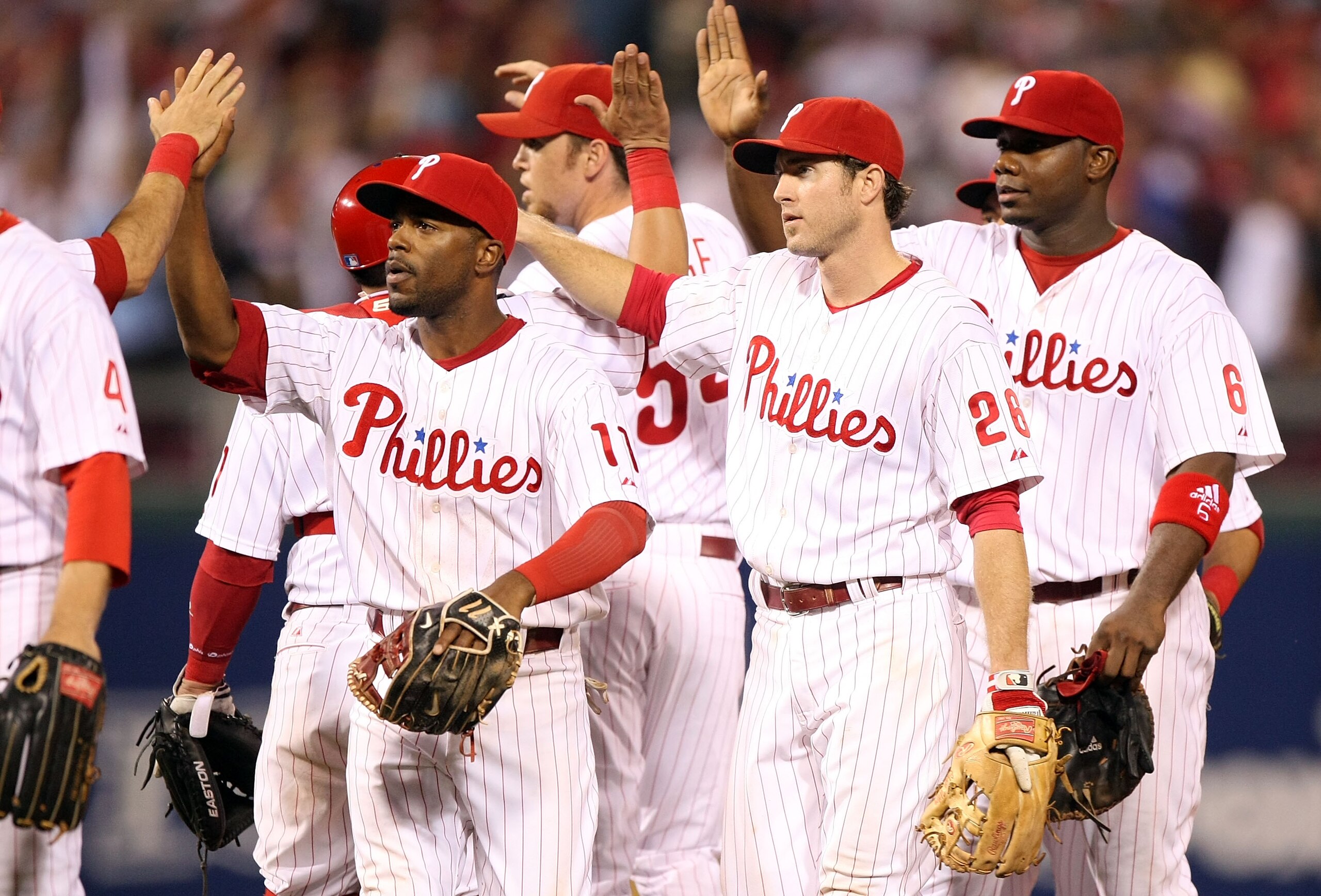 PHILADELPHIA - OCTOBER 09:  (L-R) Jimmy Rollins #11, Chase Utley #26 and Ryan Howard #6 of the Philadelphia Phillies celebrate with their teammates after their 3-2 win against the Los Angeles Dodgers in Game One of the National League Championship Series