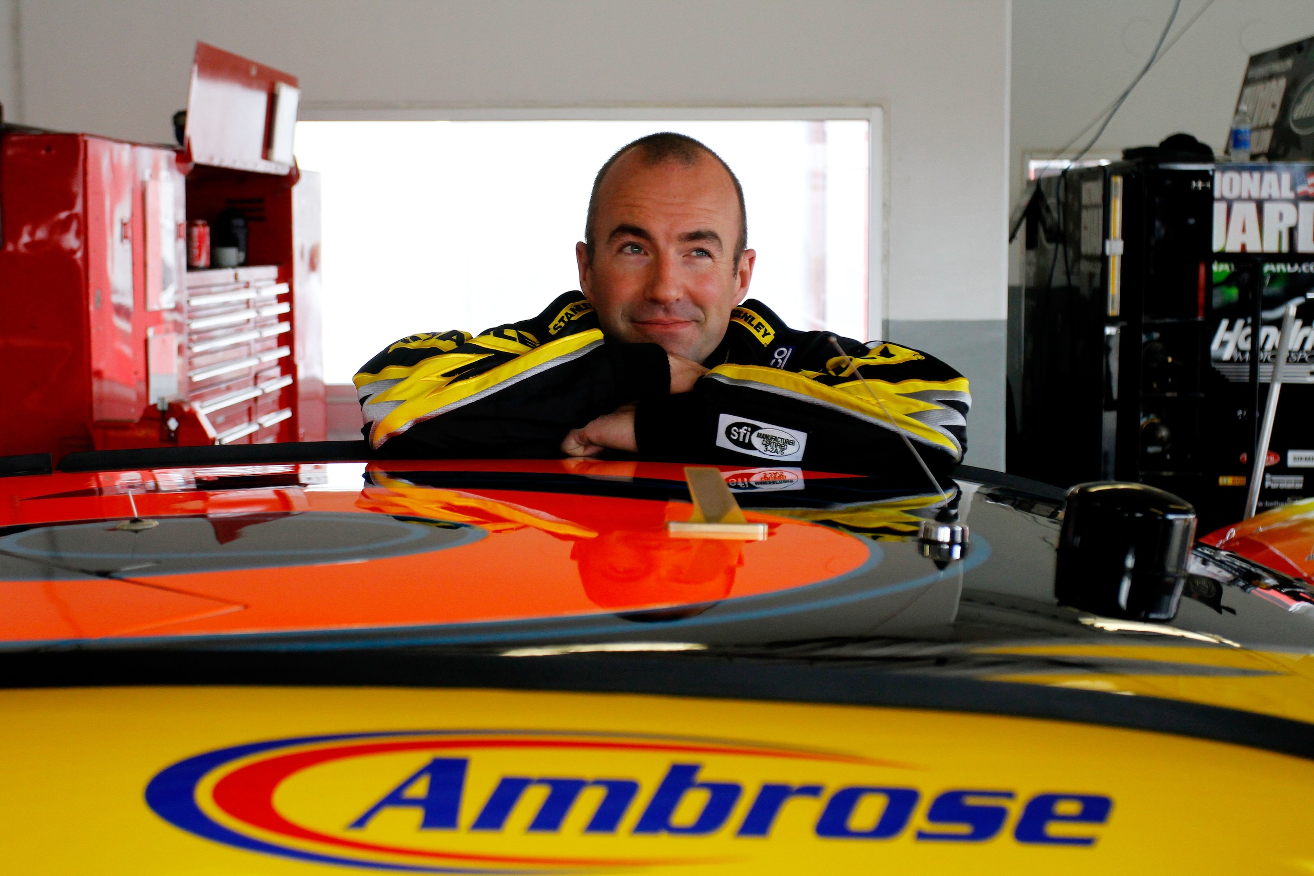 DAYTONA BEACH, FL - FEBRUARY 16:  Marcos Ambrose, driver of the #9 Stanley Ford, stands next to his car in the garage during practice for the NASCAR Sprint Cup Series Daytona 500 at Daytona International Speedway on February 16, 2011 in Daytona Beach, Flo