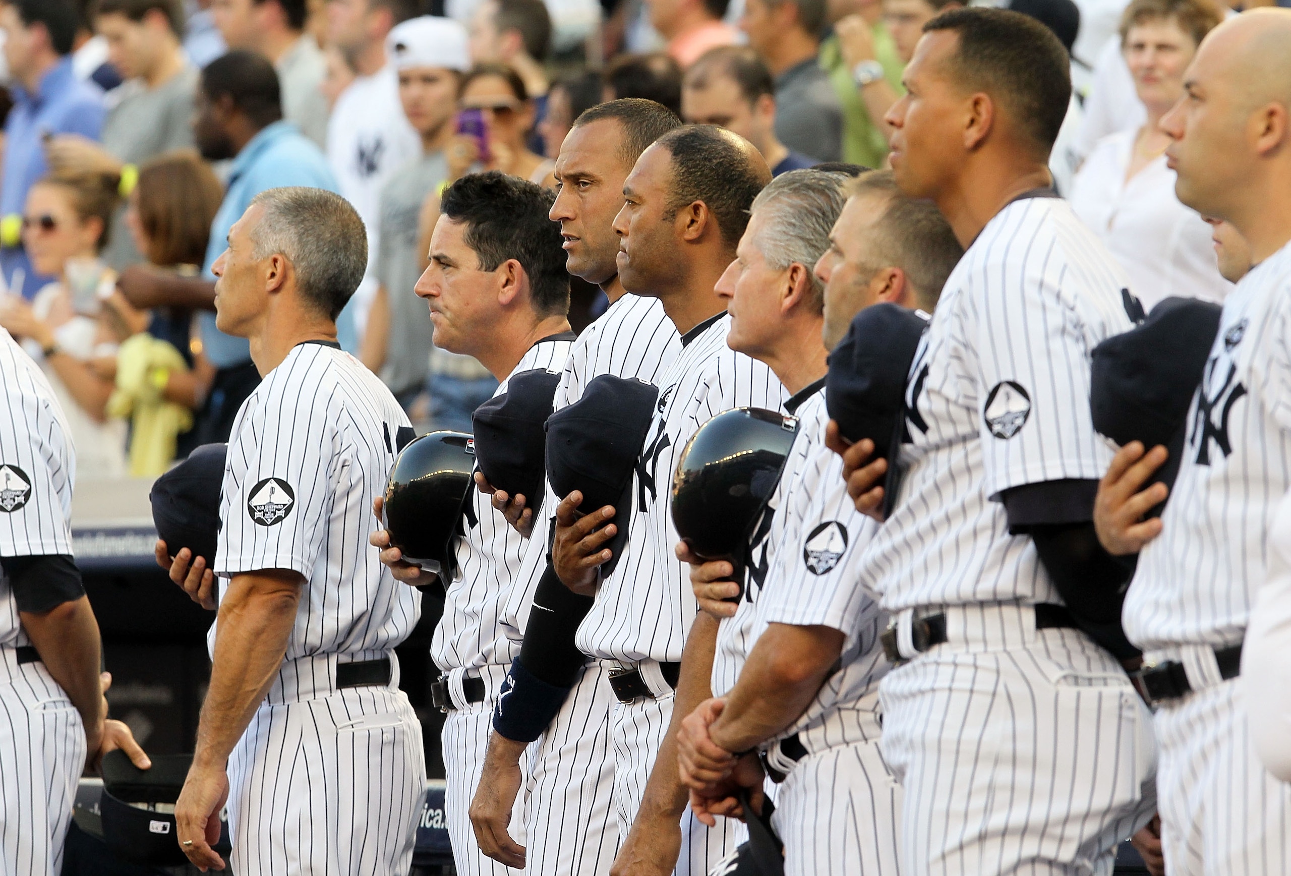 NEW YORK - JULY 16:  Derek Jeter #2 (2nd L) of the New York Yankees joins teammates and staff as they observe a moment of silence during the ceremony for owner George Steinbrenner and Yankee Stadium public address announcer Bob Sheppard before the game ag
