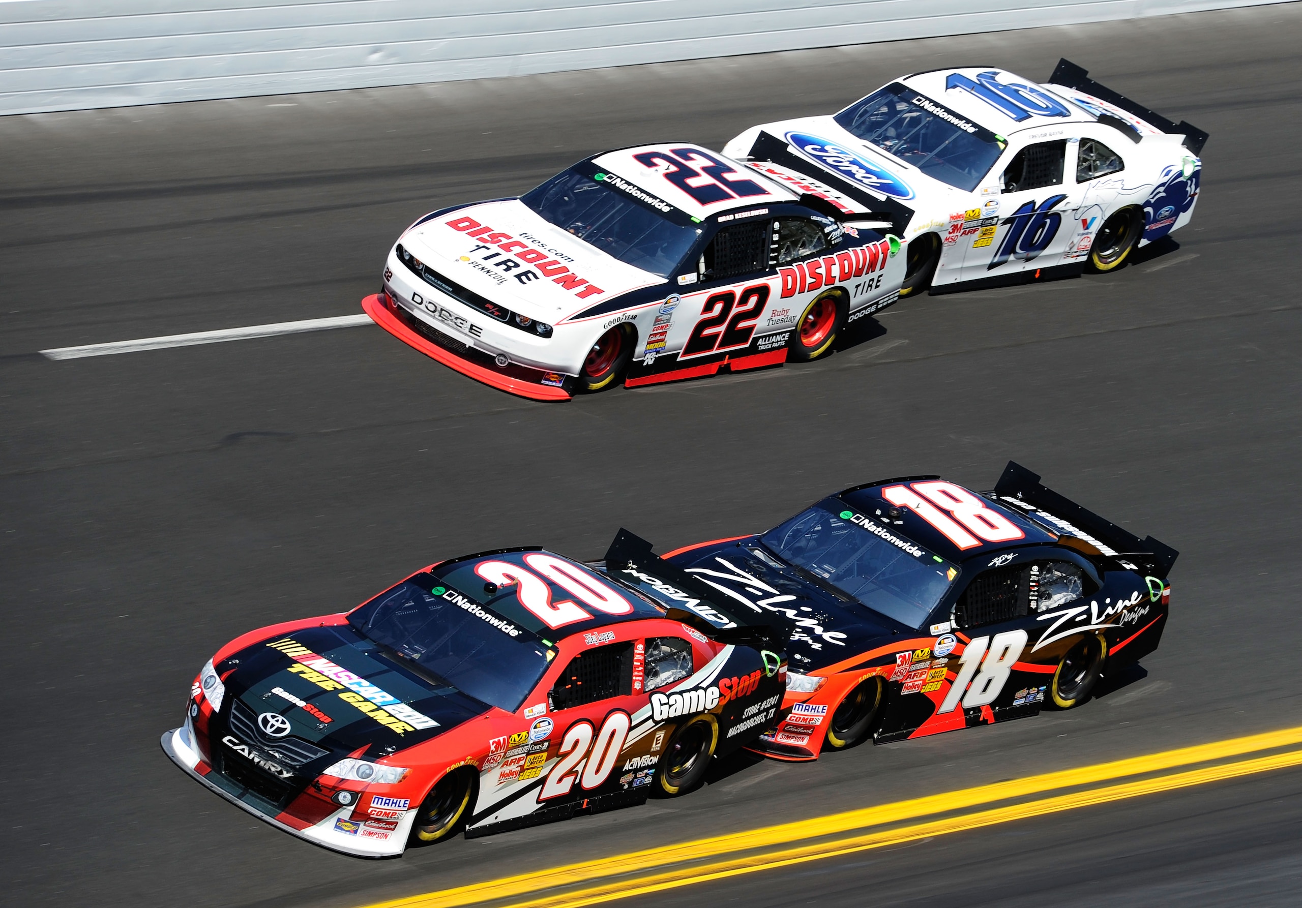 DAYTONA BEACH, FL - FEBRUARY 19:  Joey Logano, driver of the #20 GameStop Toyota, and Brad Keselowski, driver of the #22 Discount Tire Dodge, lead Kyle Busch, driver of the #18 Z-Line Designs Toyota, and Trevor Bayne, driver of the #16 Drive One Ford, dur