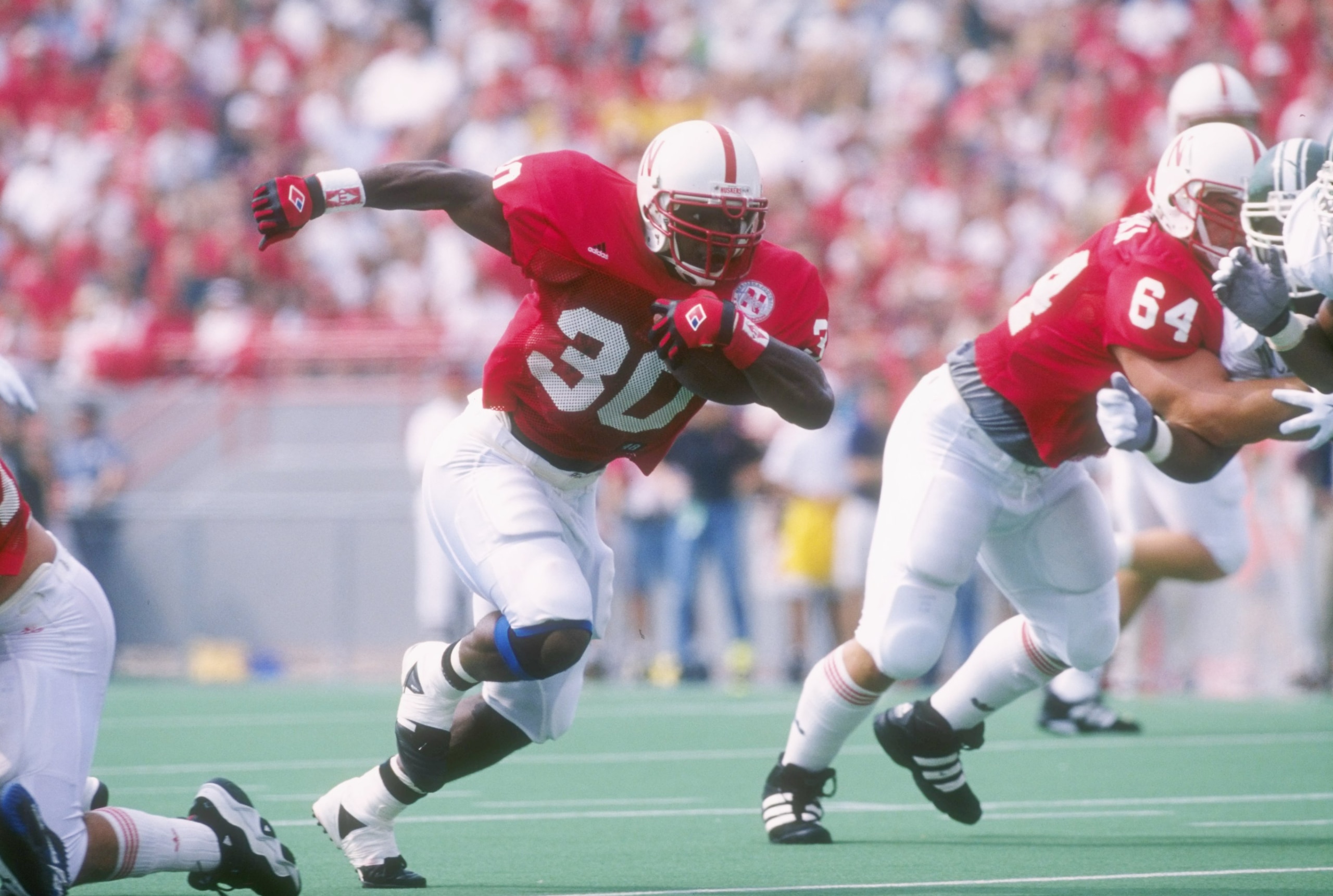 7 Sep 1996: Running back Ahman Green #30 of the Nebraska Cronhuskers scans the field for pursuing defenders from the Michigan State Spartans as he bursts through a hole in the offensive line during a carry in the Cornhuskers 55-14 victory over the Spart 7 Sep 1996: Running back Ahman Green #30 of the Nebraska Cronhuskers scans the field for pursuing defenders from the Michigan State Spartans as he bursts through a hole in the offensive line during a carry in the Cornhuskers 55-14 victory over the Spart
