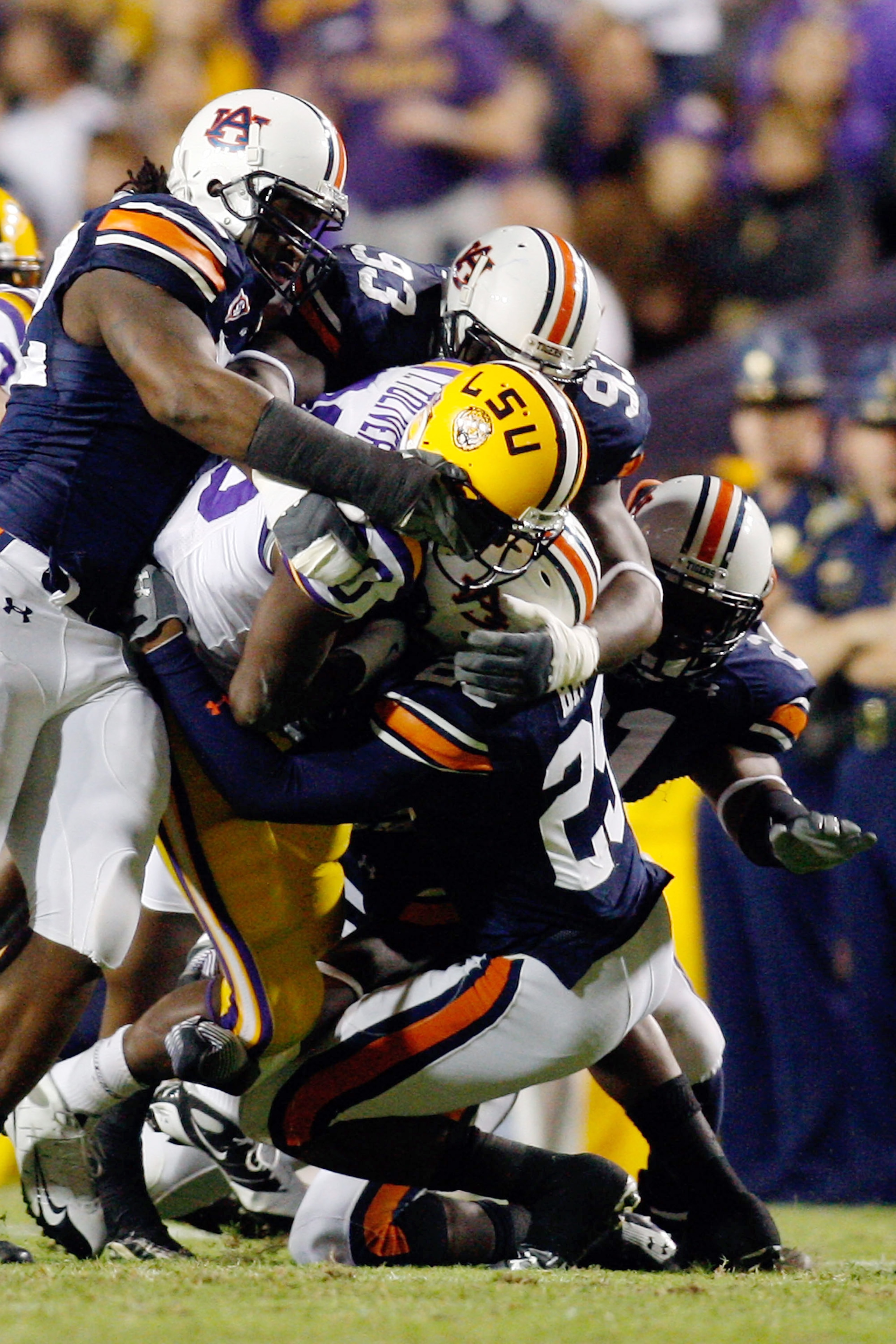 BATON ROUGE, LA - OCTOBER 24:  Terrance Toliver #80 of the Louisiana State University Tigers is tackled by Daren Bates #25 of the Auburn Tigers at Tiger Stadium on October 24, 2009 in Baton Rouge, Louisiana.  (Photo by Chris Graythen/Getty Images)
