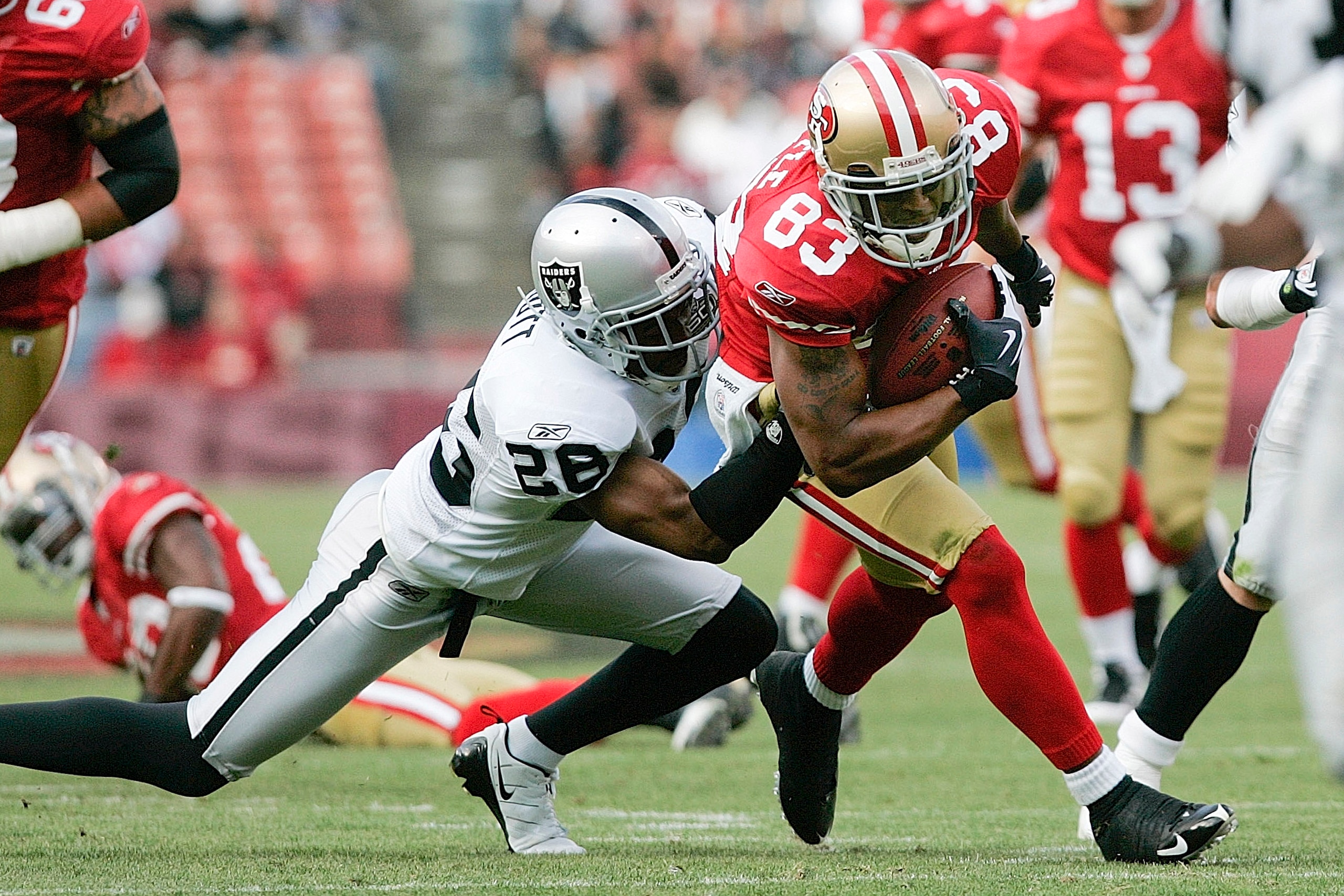 SAN FRANCISCO - AUGUST 22:  San Francisco 49ers wide receiver Arnaz Battle #83 tries to break free from Oakland Raiders Oakland Raiders cornerback Stanford Routt # 26 during the 1st quarter as the San Francisco 49ers host the Oakland Raiders at Candlestic
