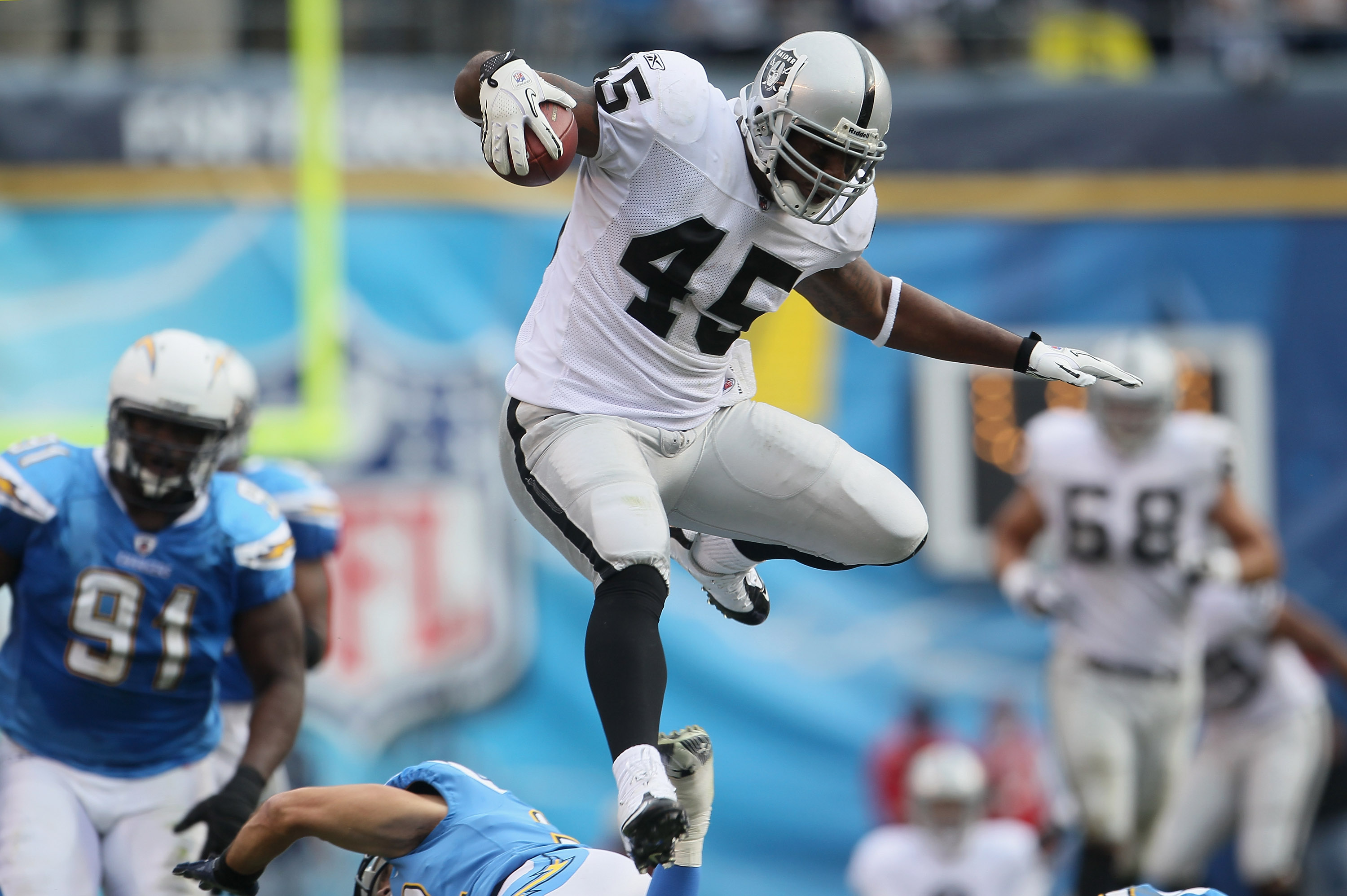 SAN DIEGO - DECEMBER 05:  Fullback Marcel Reece #45 of the Oakland Raiders leaps over Eric Weddle (not pictured) #32 of the San Diego Chargers in the second quarter at Qualcomm Stadium on December 5, 2010 in San Diego, California. The Raiders defeated the