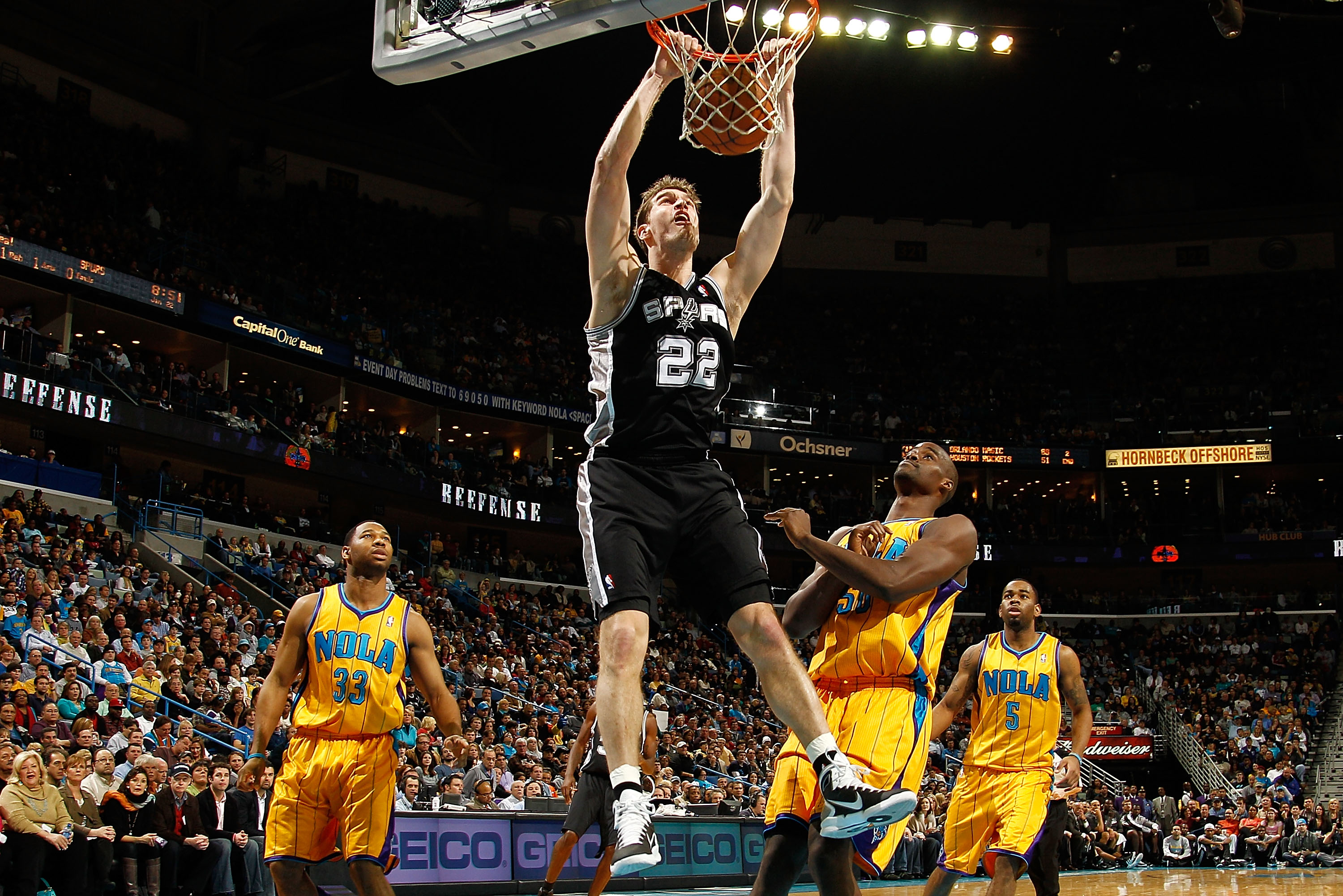NEW ORLEANS, LA - JANUARY 22:  Tiago Splitter #22 of the San Antonio Spurs dunks the ball over Emeka Okafor #50 of the New Orleans Hornets at the New Orleans Arena on January 22, 2011 in New Orleans, Louisiana.  The Hornets defeated the Spurs 96-72.  NOTE