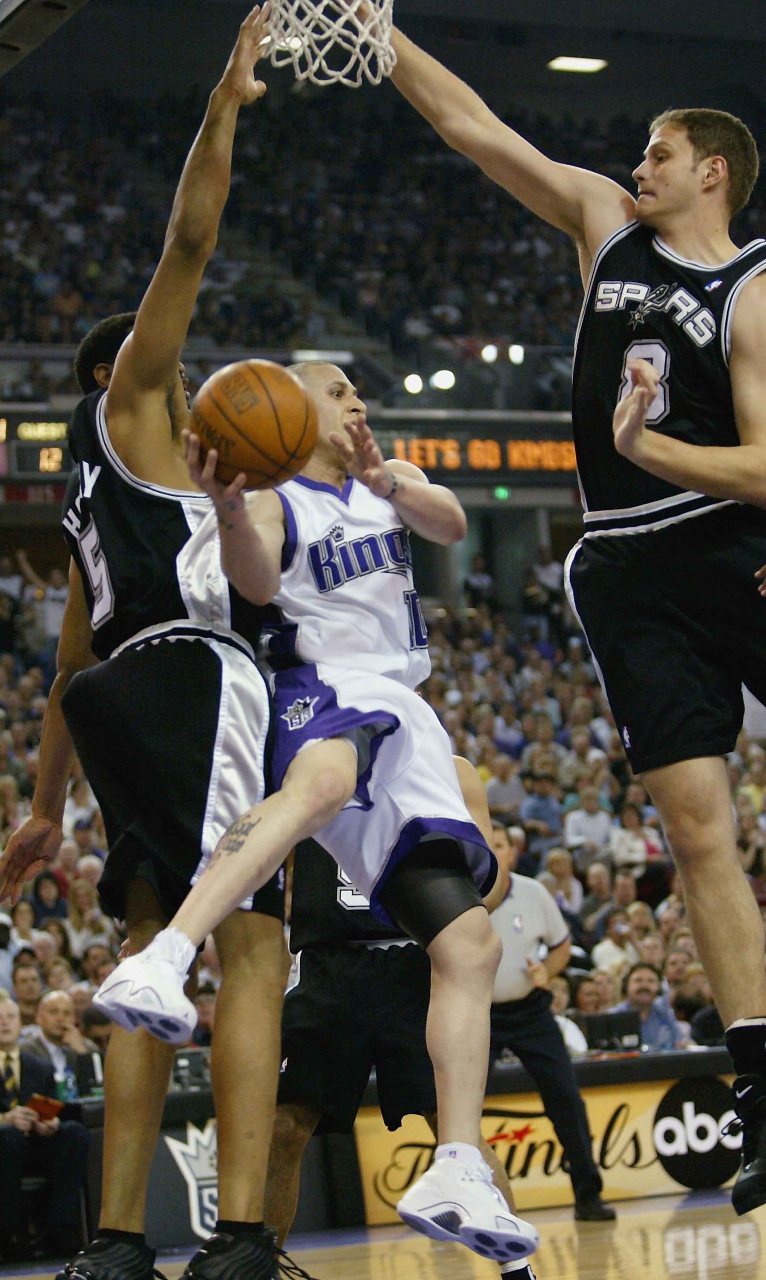 SACRAMENTO, CA - MAY 5:  Mike Bibby #10 of the Sacramento Kings passes the ball off between Rasho Nesterovic #8 and Robert Horry #5 of the San Antonio Spurs in game six of the Western Conference Quarterfinals, during the 2006 NBA Playoffs on May 5, 2006 a
