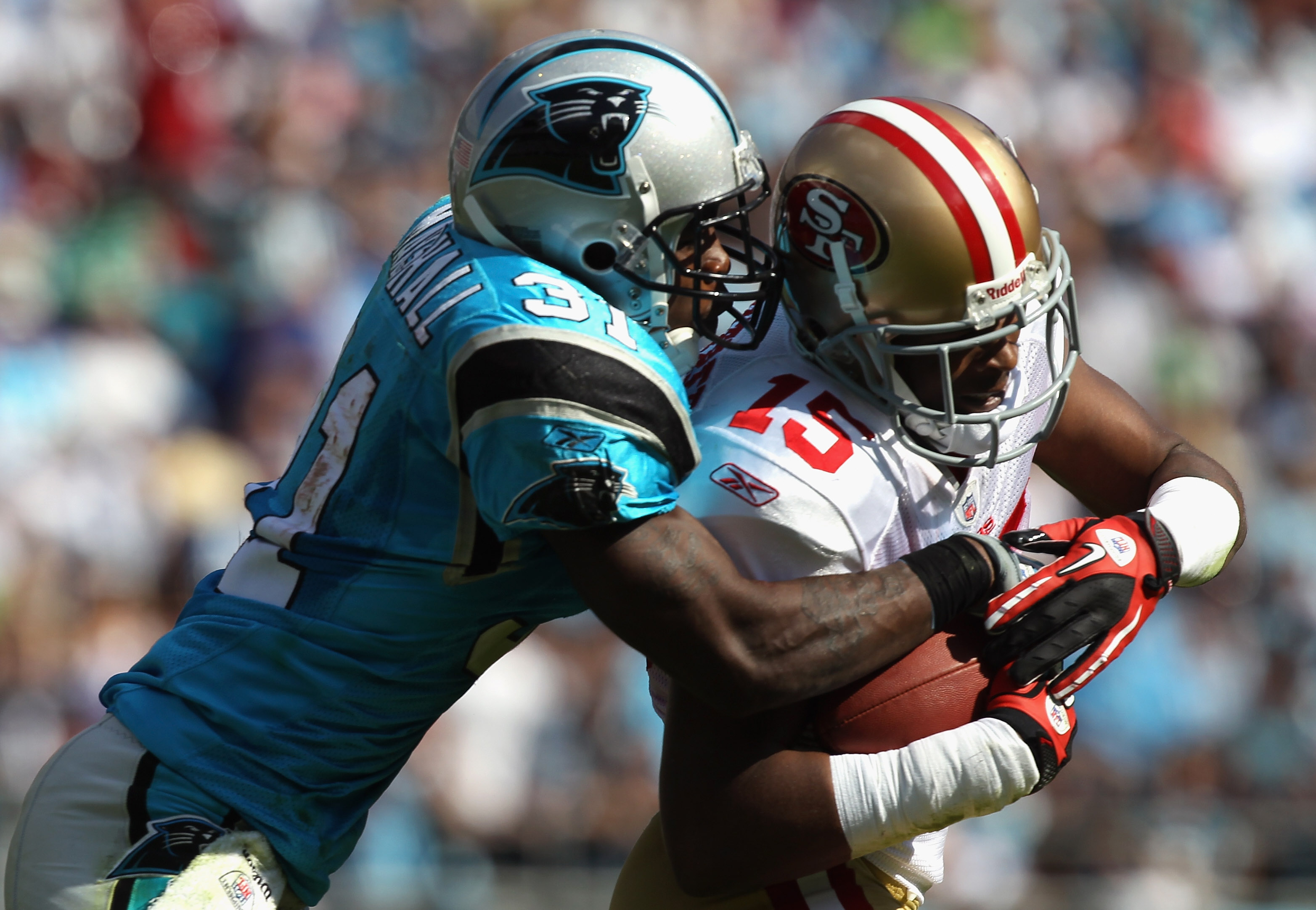 CHARLOTTE, NC - OCTOBER 24:  Michael Crabtree #15 of the San Francisco 49ers is tackled by Richard Marshall #31 of the Carolina Panthers during their game at Bank of America Stadium on October 24, 2010 in Charlotte, North Carolina.  (Photo by Streeter Lec