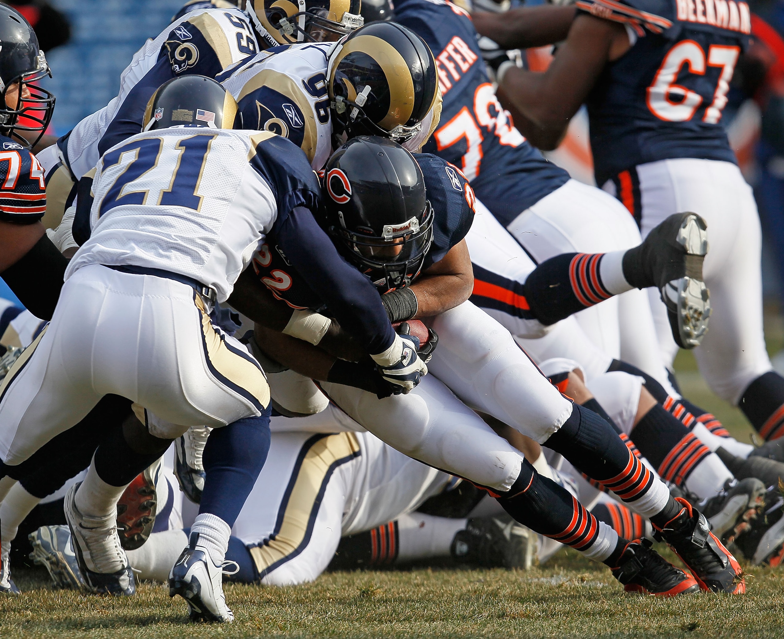 CHICAGO - DECEMBER 06: Matt Forte #22 of the Chicago Bears is tackled by Oshiomogho Atogwe #21 and James Hall #96 of the St. Louis Rams at Soldier Field on December 6, 2009 in Chicago, Illinois. The Bears defeated the Rams 17-9. (Photo by Jonathan Daniel/