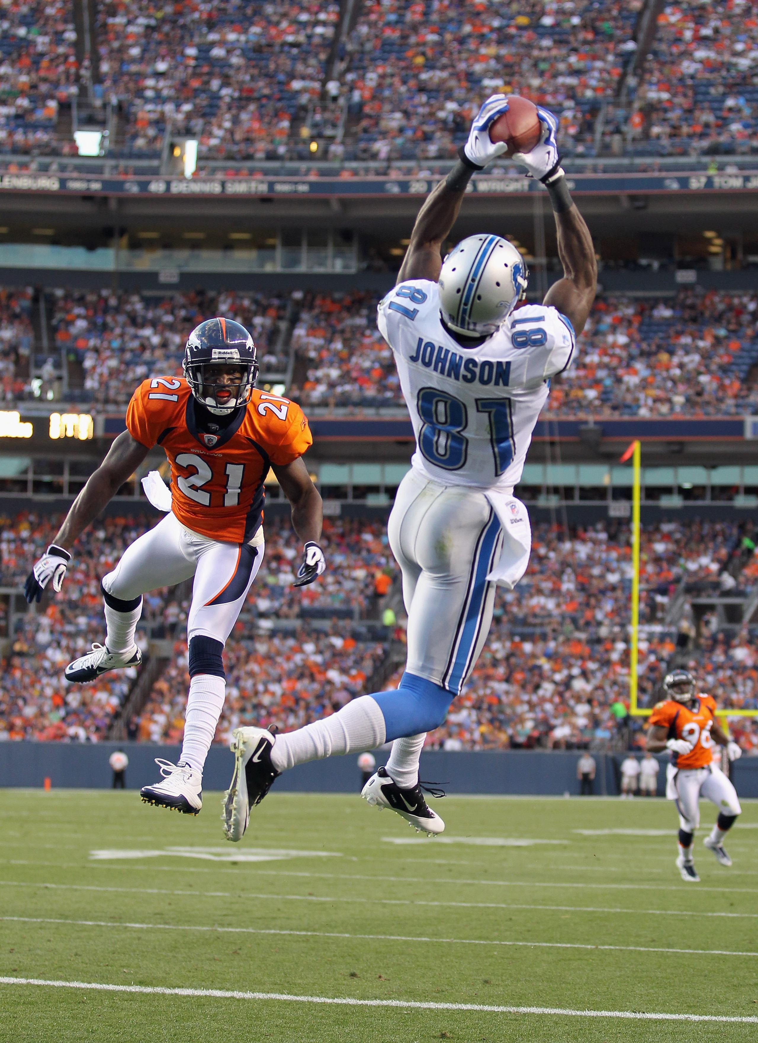 DENVER - AUGUST 21:  Calvin Johnson  #81 of the Detroit Lions makes a 20 yard touchdown catch as Andre Goodman #21 of the Denver Broncos defends  during preseason NFL action at INVESCO Field at Mile High on August 21, 2010 in Denver, Colorado. The touchdo