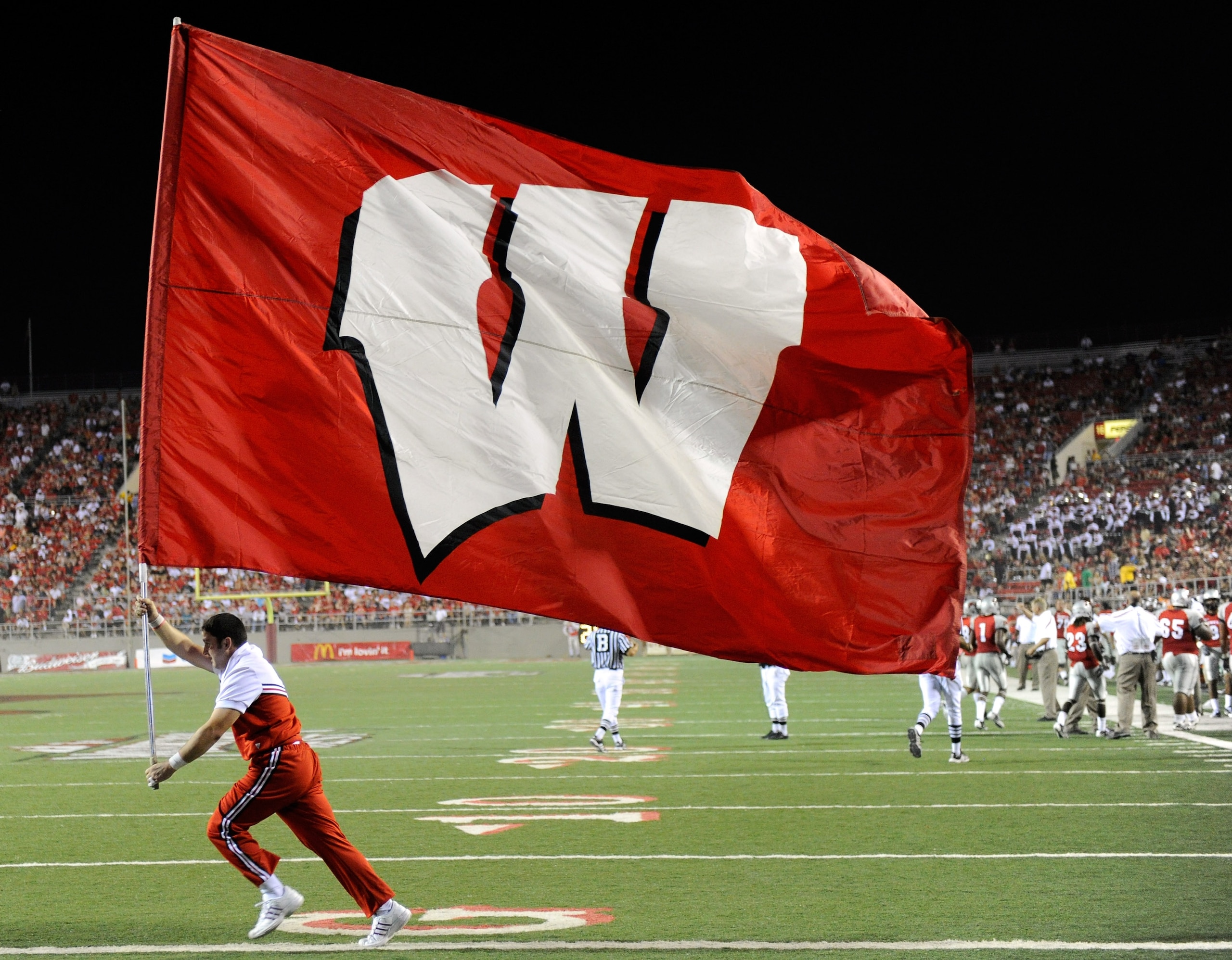 LAS VEGAS - SEPTEMBER 04:  A Wisconsin Badgers cheerleader runs a flag through the end zone after a Wisconsin touchdown against the UNLV Rebels at Sam Boyd Stadium September 4, 2010 in Las Vegas, Nevada. Wisconsin won 41-21.  (Photo by Ethan Miller/Getty