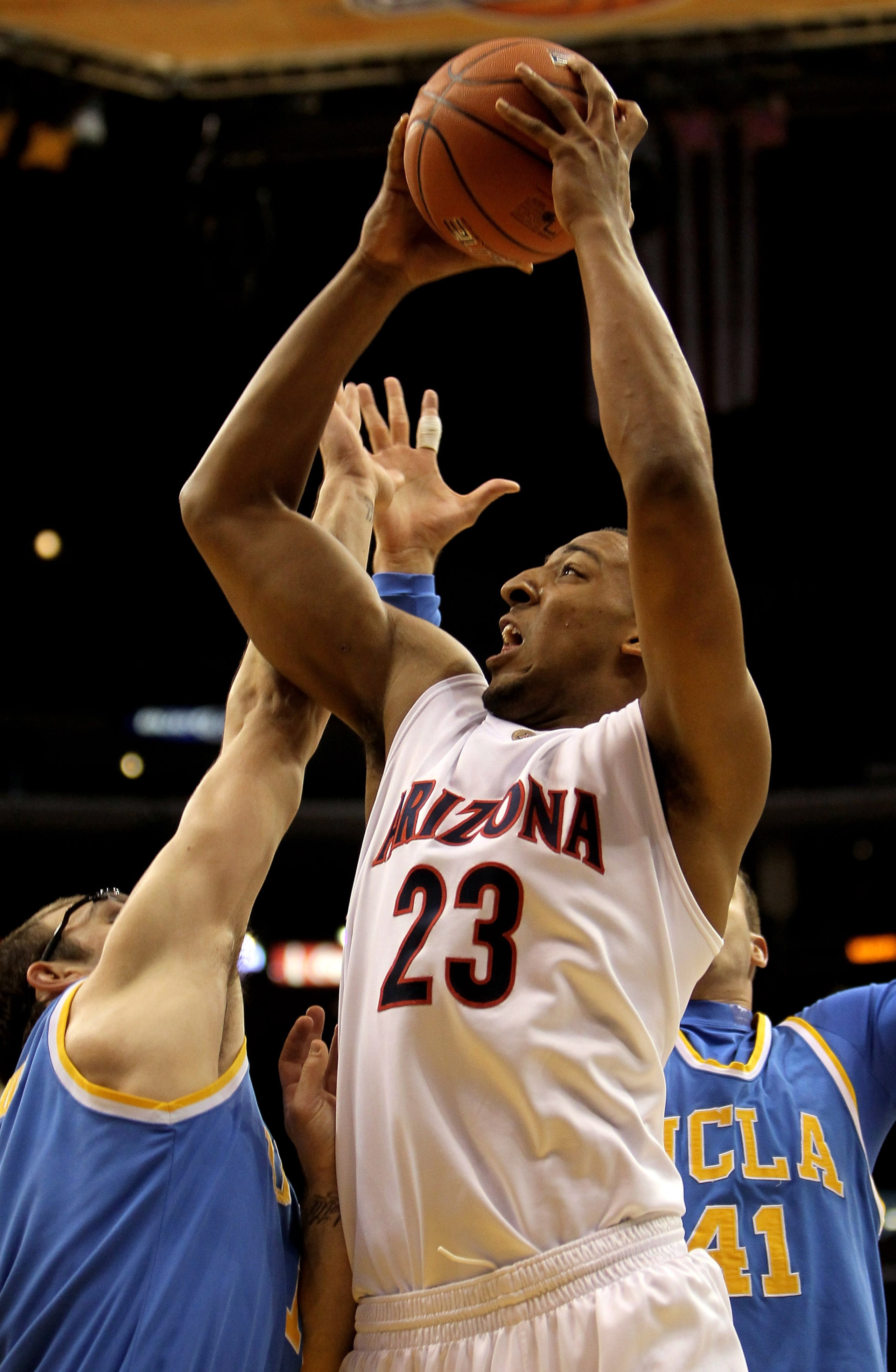 LOS ANGELES - MARCH 11:   Derrick Williams #23 of the Arizona Wildcats shoots over Reeves Nelson #11 of the UCLA Bruins during the quarterfinals of the Pac-10 Basketball Tournament at Staples Center on March 11, 2010 in Los Angeles, California.  (Photo by