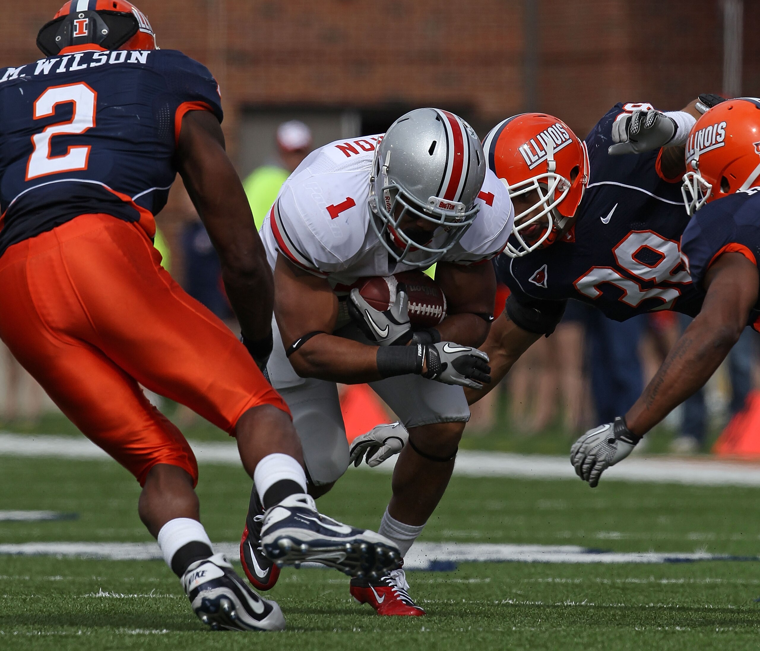 CHAMPAIGN, IL - OCTOBER 02: Dan Herron #1 of the Ohio State Buckeyes is tackled by (L-R) Martez Wilson #2, Ian Thomas #38 and Trulon Henry #9 of the Illinois Fighting Illini at Memorial Stadium on October 2, 2010 in Champaign, Illinois. Ohio State defeate