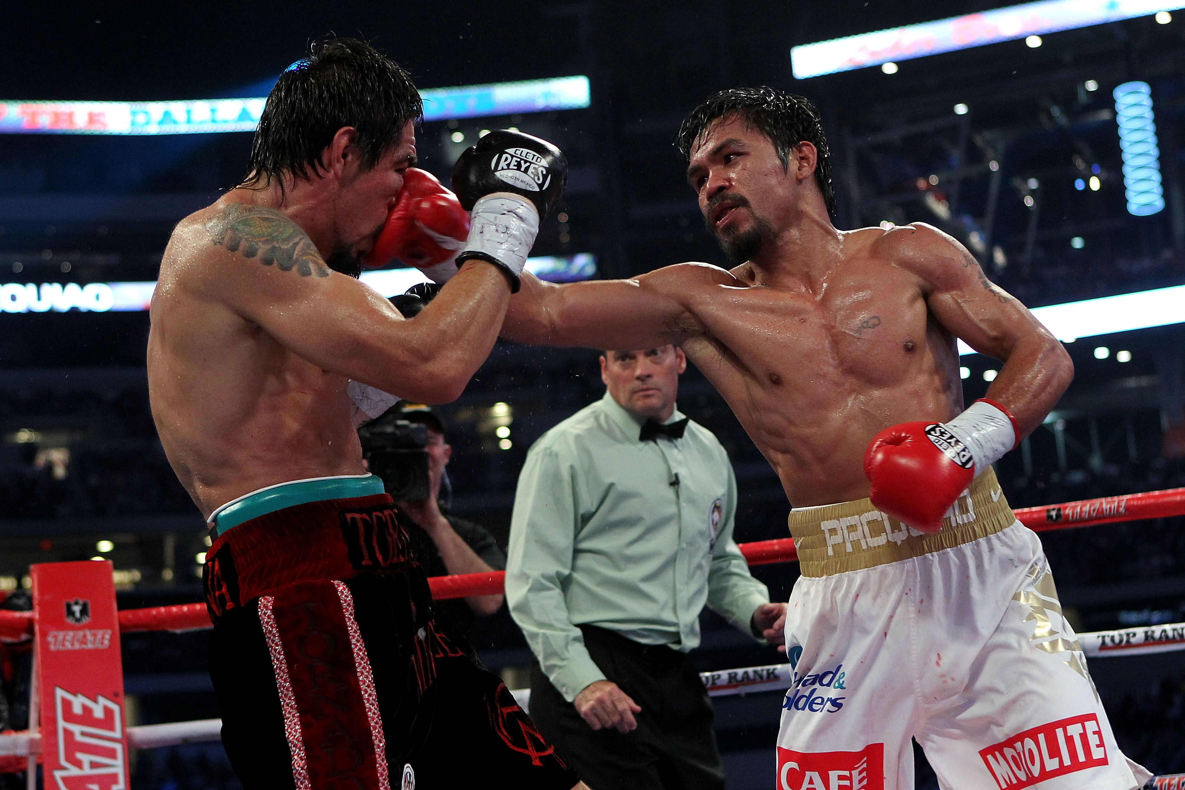 ARLINGTON, TX - NOVEMBER 13: Manny Pacquiao (white trunks) of the Philippines lands a punch against Antonio Margarito (black trunks) of Mexico during their WBC World Super Welterweight Title bout at Cowboys Stadium on November 13, 2010 in Arlington, Texa