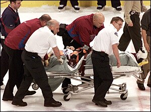 Steve Moore is taken off the ice on a stretcher