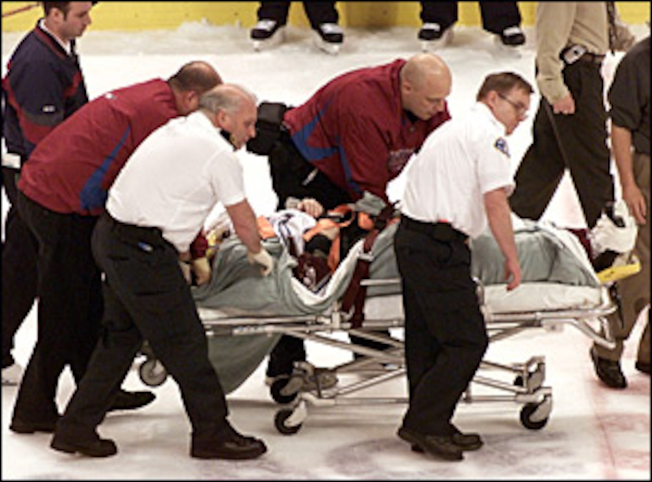 Steve Moore is taken off the ice on a stretcher