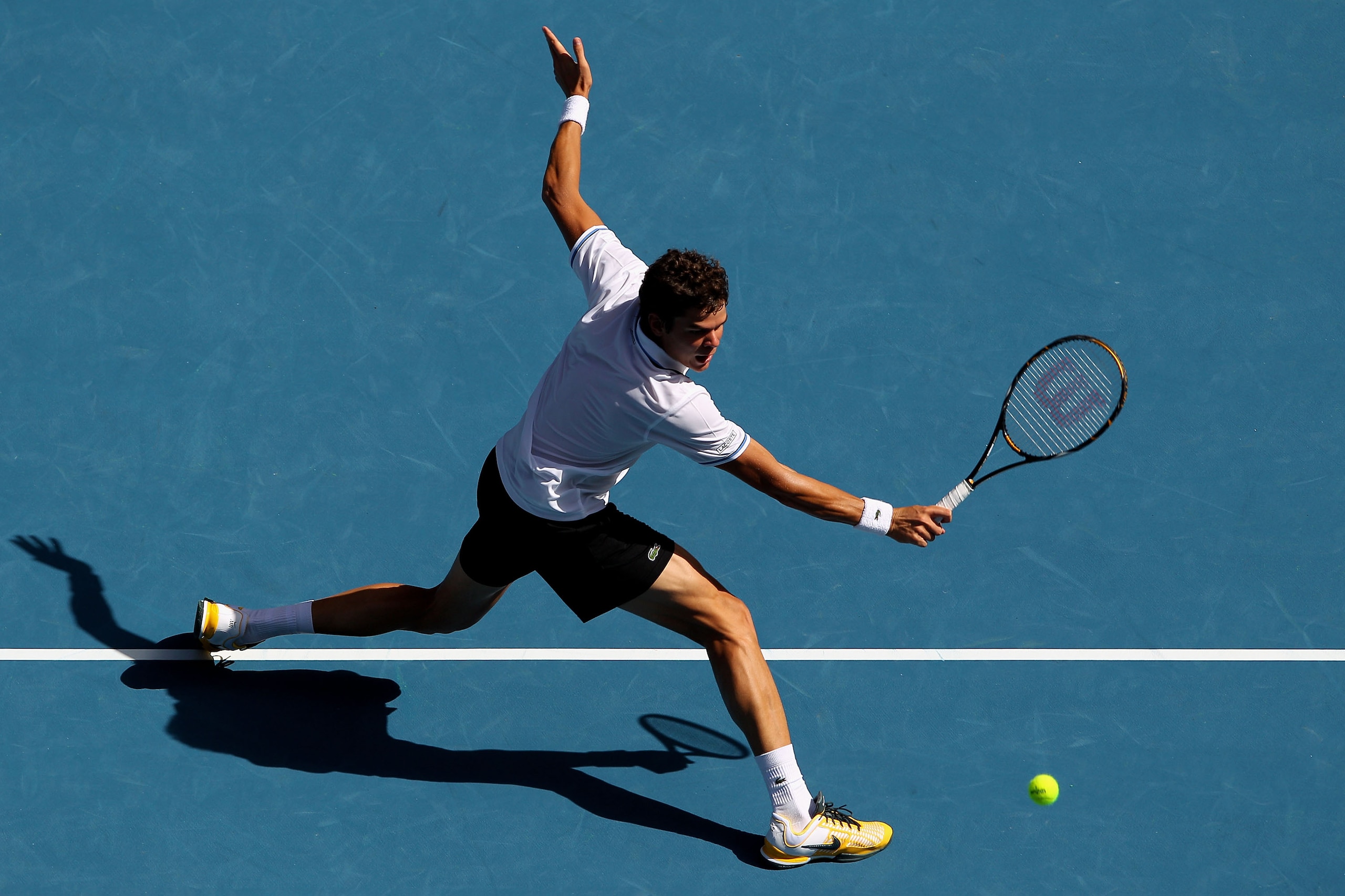 MELBOURNE, AUSTRALIA - JANUARY 24:  Milos Raonic of Canada plays a backhand in his fourth round match against David Ferrer of Spain during day eight of the 2011 Australian Open at Melbourne Park on January 24, 2011 in Melbourne, Australia.  (Photo by Came