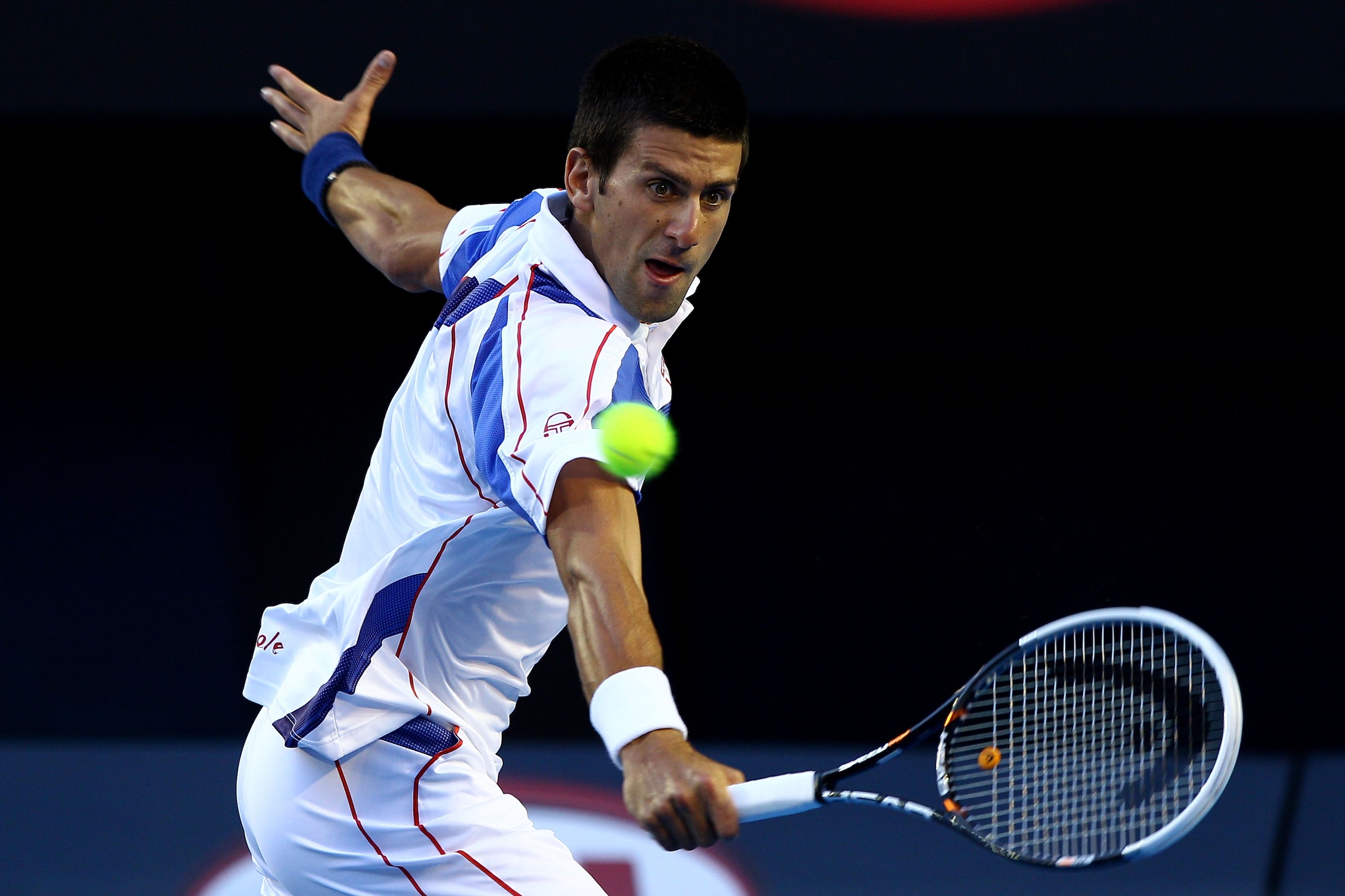 MELBOURNE, AUSTRALIA - JANUARY 27:  Novak Djokovic of Serbia plays a backhand in his semifinal match against Roger Federer of Switzerland during day eleven of the 2011 Australian Open at Melbourne Park on January 27, 2011 in Melbourne, Australia.  (Photo 