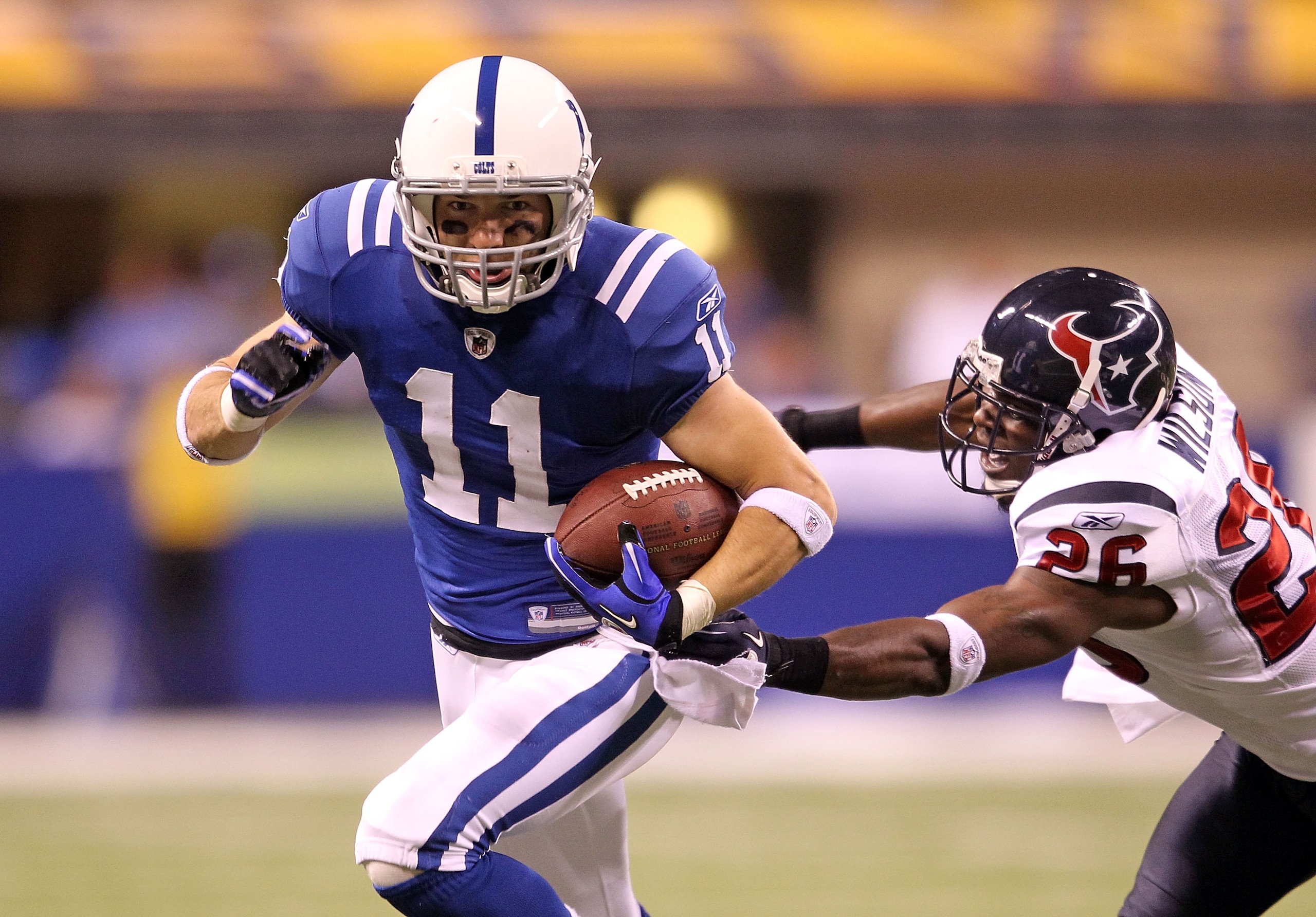 INDIANAPOLIS - NOVEMBER 01: Anthony Gonzalez #11 of Indianapolis Colts runs with the ball while defended by Eugene Wilson #26 of the Houston Texans during the NFL game at Lucas Oil Stadium on November 1, 2010 in Indianapolis, Indiana.  (Photo by Andy Lyon