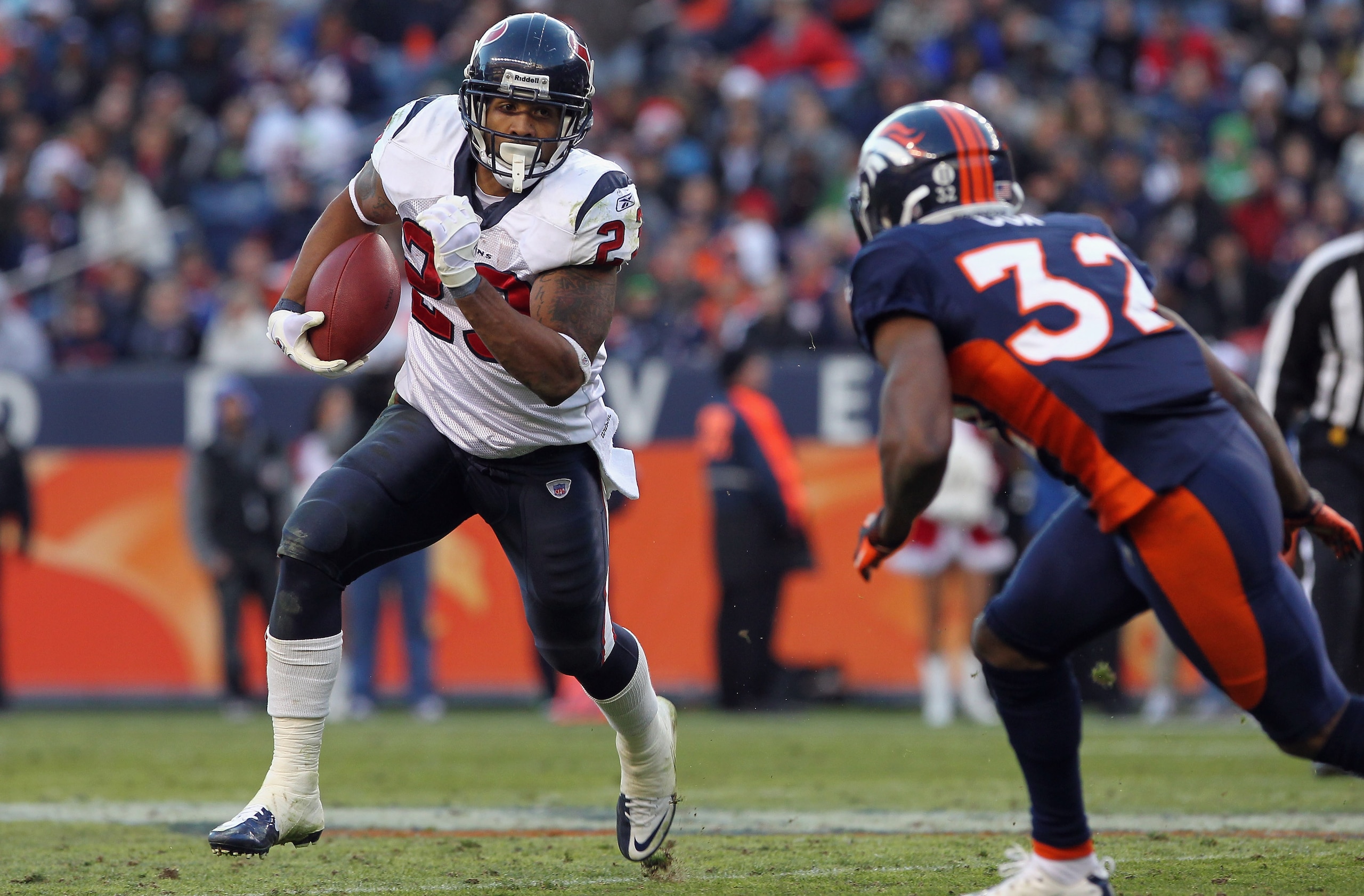 DENVER - DECEMBER 26:  Running back Arian Foster #23 of the Houston Texas rushes with the ball as cornerback Perrish Cox #32 of the Denver Broncos defends at INVESCO Field at Mile High on December 26, 2010 in Denver, Colorado. The Broncos defeated the Tex