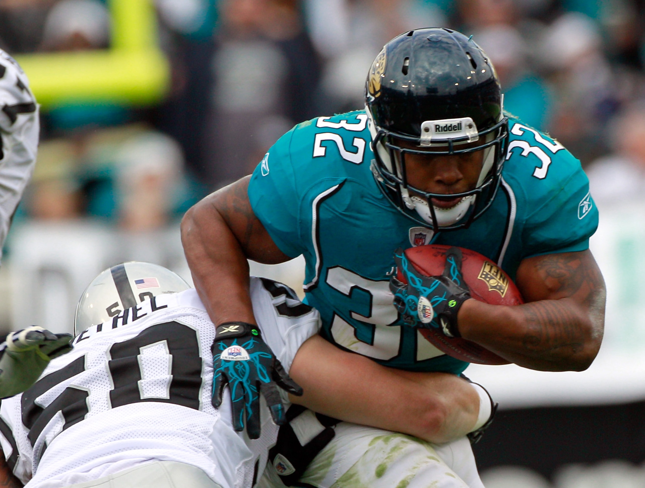 JACKSONVILLE, FL - DECEMBER 12:  Maurice Jones-Drew #32 of the Jacksonville Jaguars breaks the tackle of Travis Goethel #50 of the Oakland Raiders during the game at EverBank Field on December 12, 2010 in Jacksonville, Florida.  (Photo by Sam Greenwood/Ge