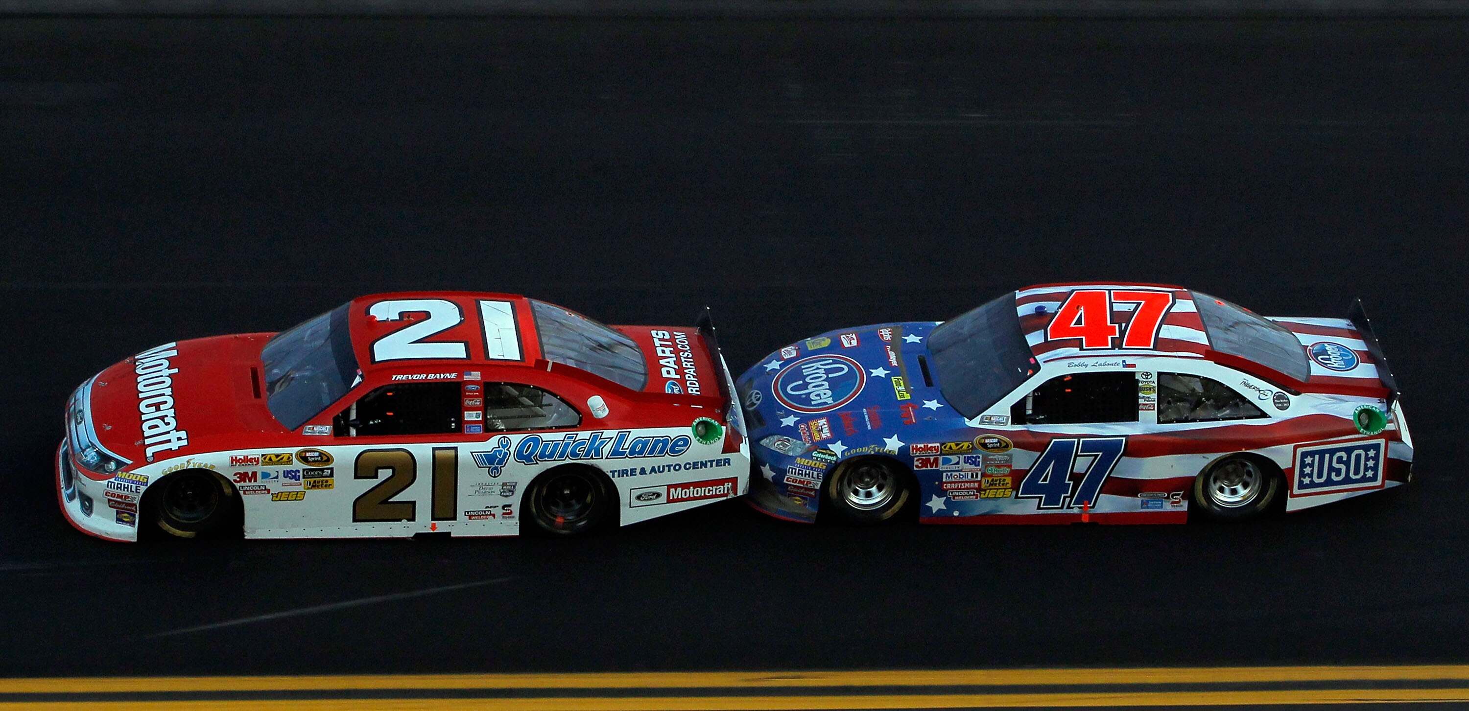 DAYTONA BEACH, FL - FEBRUARY 20:  Trevor Bayne, driver of the #21 Motorcraft/Quick Lane Ford, and Bobby Labonte, driver of the #47 Kroger/USO Toyota, race during the NASCAR Sprint Cup Series Daytona 500 at Daytona International Speedway on February 20, 20