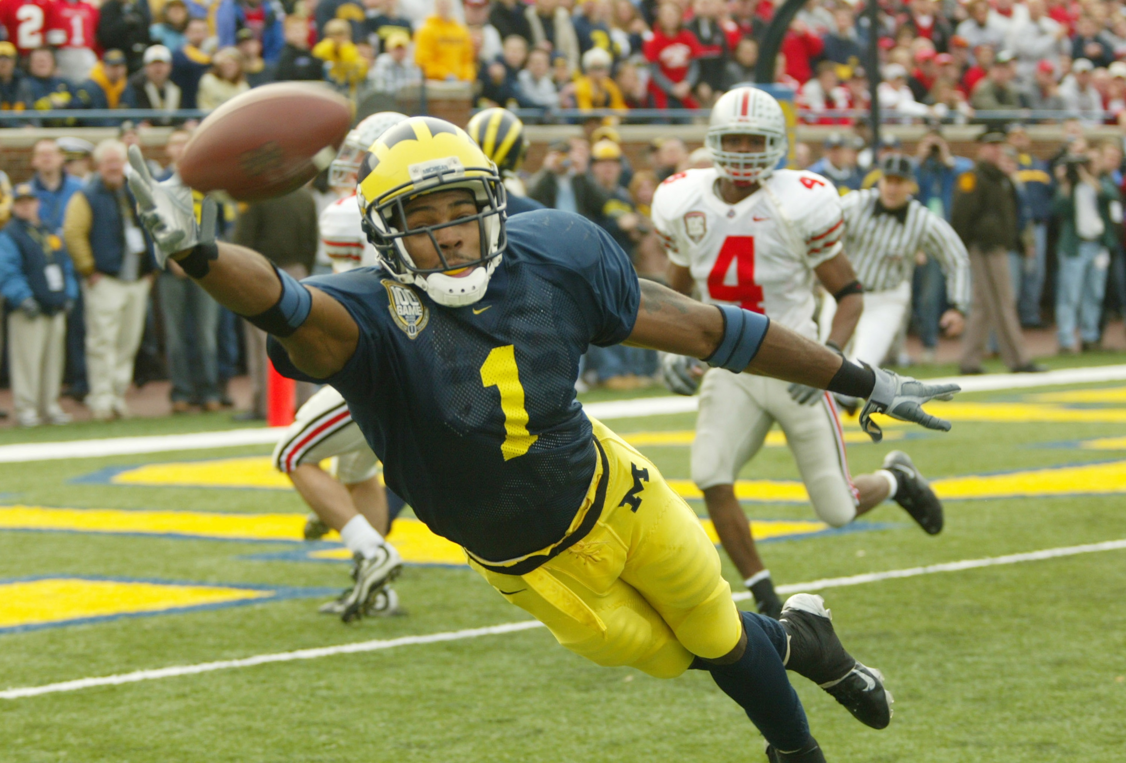 ANN ARBOR, MI - NOVEMBER 22: Braylon Edwards #1 of the Michigan Wolverines dives for a pass from John Navarre as Will Allen #4 of the Ohio State Buckeyes watches behind him during the 100th meeting of the two teams November 22, 2003 at Michigan Stadium in ANN ARBOR, MI - NOVEMBER 22: Braylon Edwards #1 of the Michigan Wolverines dives for a pass from John Navarre as Will Allen #4 of the Ohio State Buckeyes watches behind him during the 100th meeting of the two teams November 22, 2003 at Michigan Stadium in