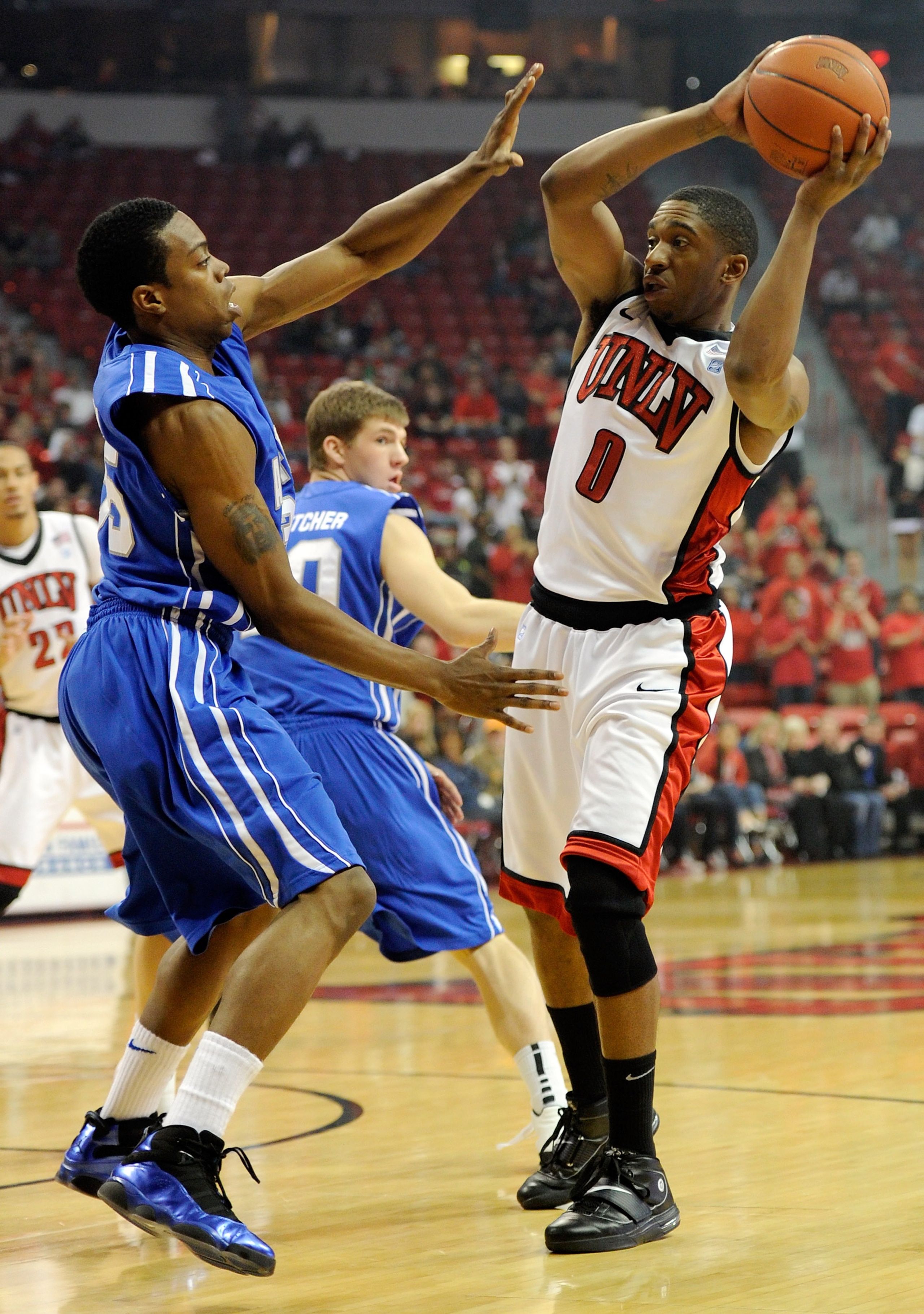 LAS VEGAS, NV - FEBRUARY 15:  Oscar Bellfield #0 of the UNLV Rebels looks to pass against Evan Washington #35 of the Air Force Falcons during their game at the Thomas & Mack Center February 15, 2011 in Las Vegas, Nevada. UNLV won 49-42.  (Photo by Ethan M