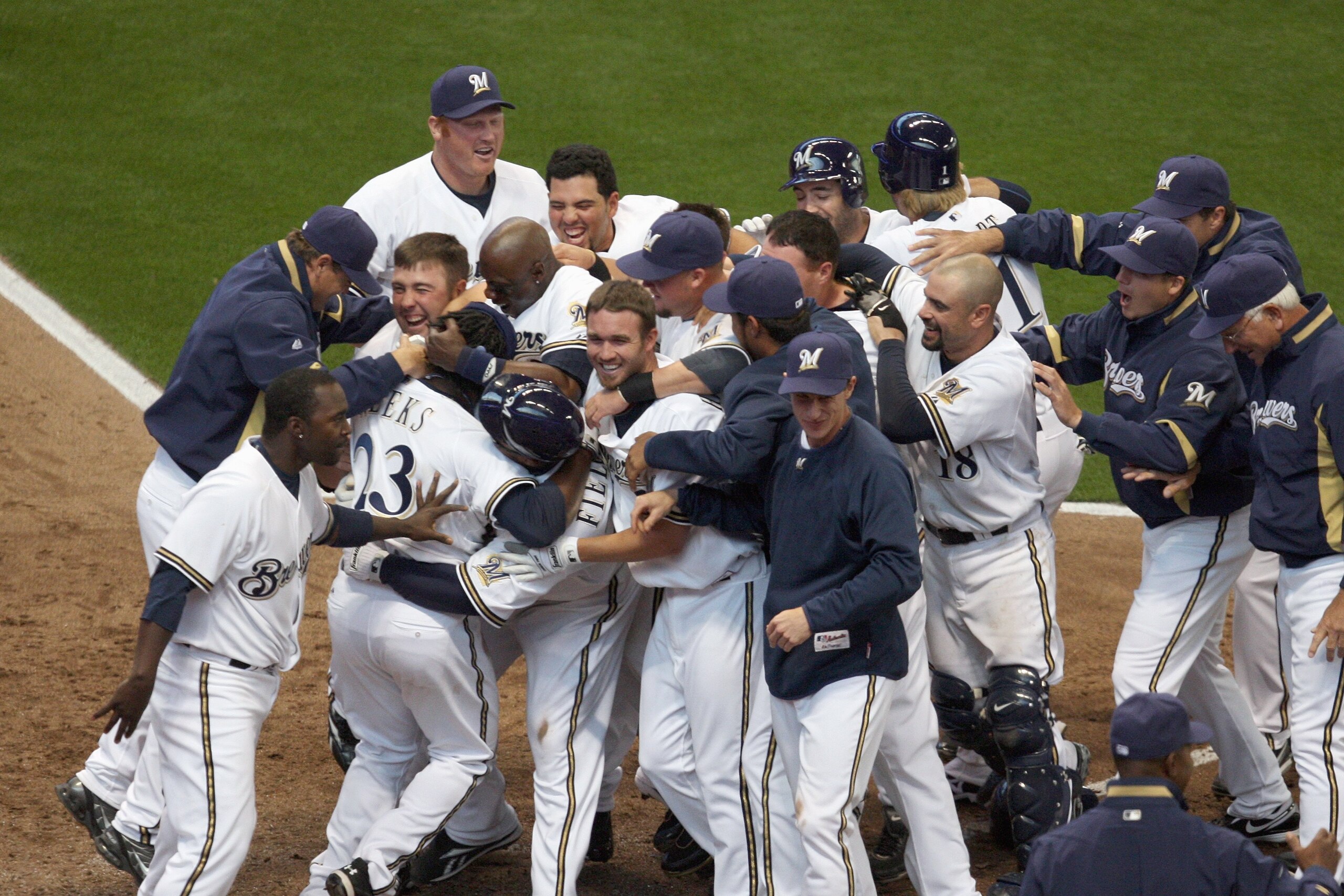 MILWAUKEE - APRIL 10: Members of the Milwaukee Brewers mob teammate Rickie Weeks #23 after Weeks scored the winning run in the bottom of the 9th inning against the Chicago Cubs during the Opening Day game on April 10, 2009 at Miller Park in Milwaukee, Wis