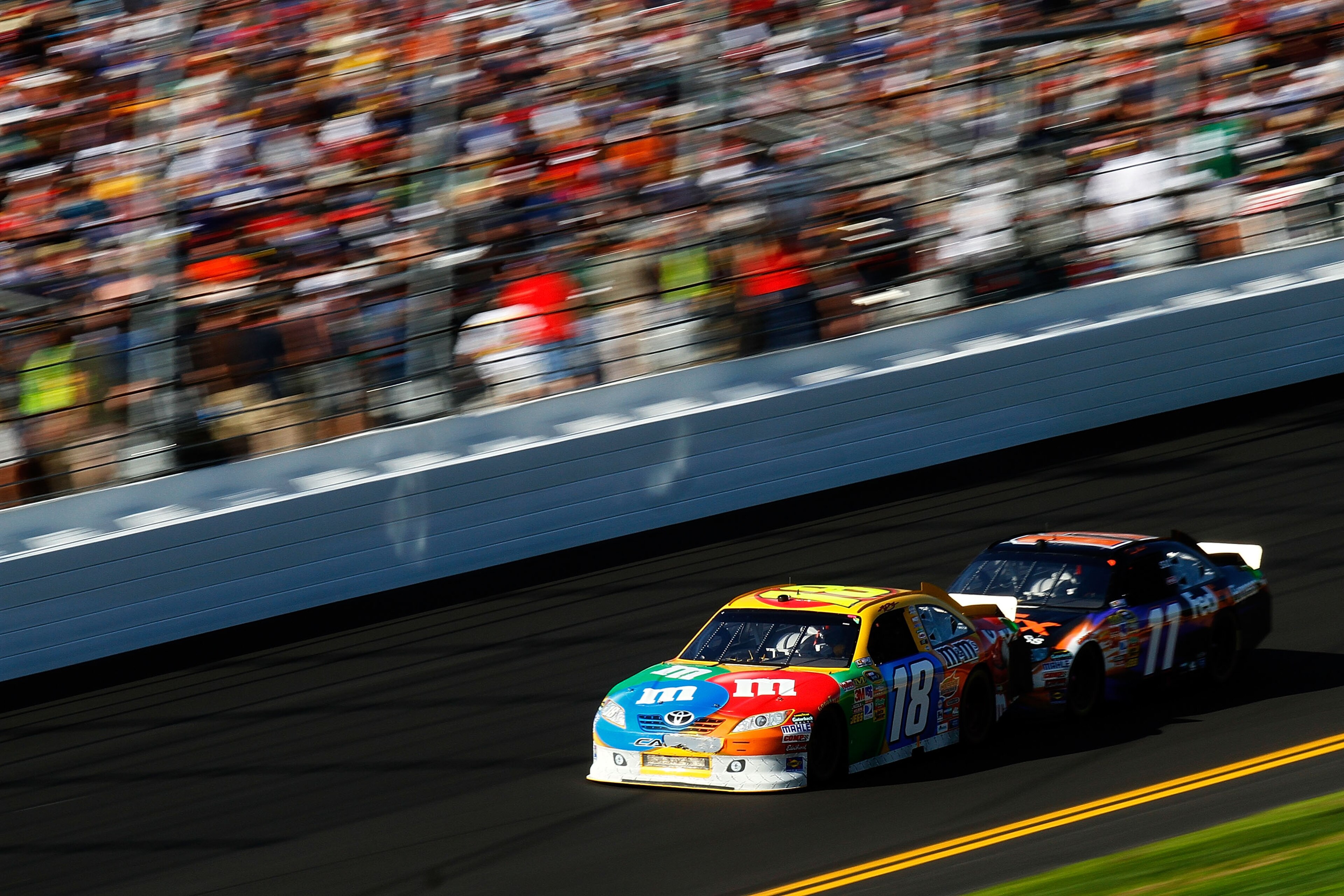 DAYTONA BEACH, FL - FEBRUARY 20:  Kyle Busch, driver of the #18 M&M's Toyota, and Denny Hamlin, driver of the #11 FedEx Toyota, race during the NASCAR Sprint Cup Series Daytona 500 at Daytona International Speedway on February 20, 2011 in Daytona Beach, F