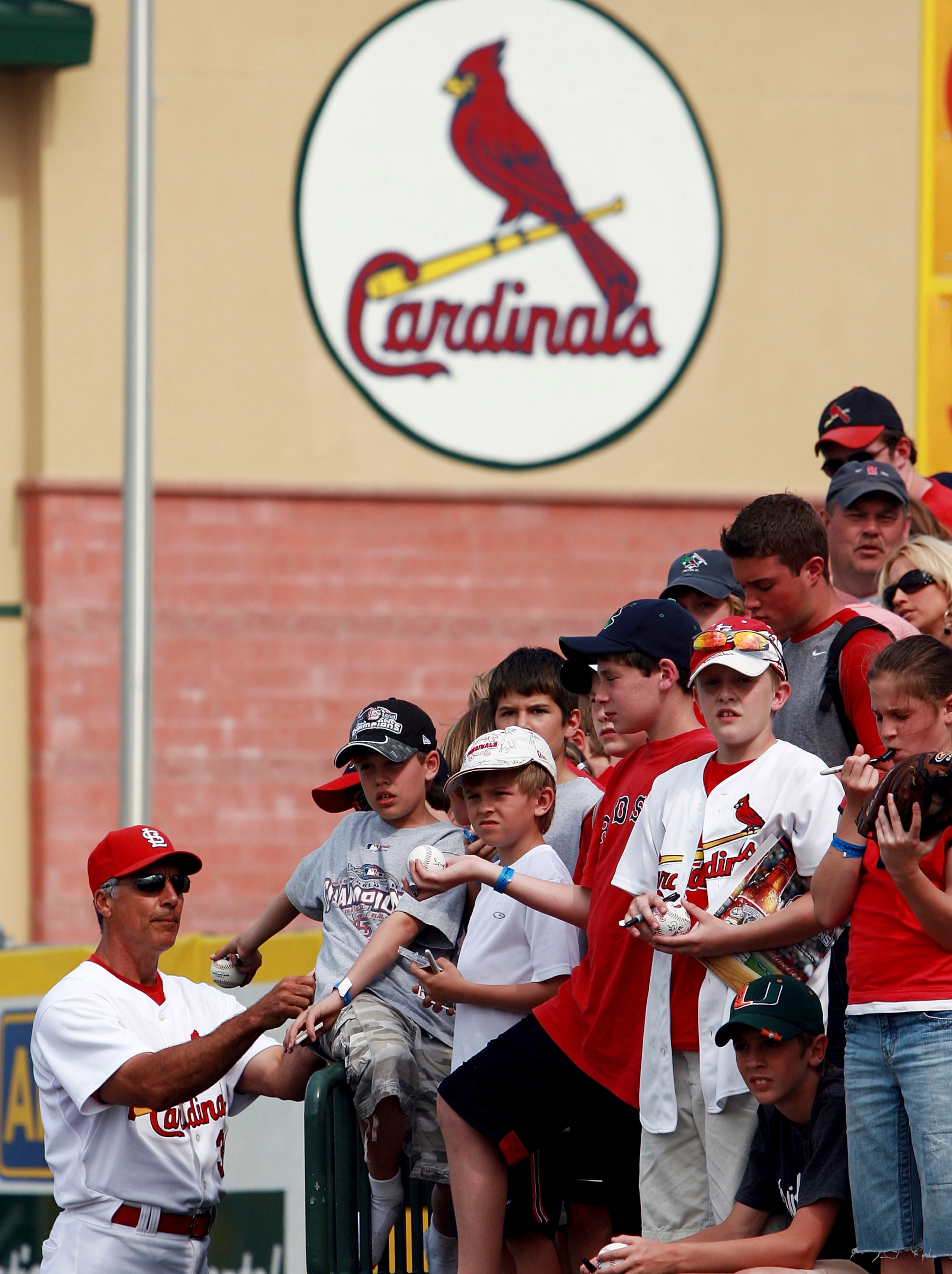JUPITER, FL - MARCH 14:  Coach Dave McKay #39 of the St. Louis Cardinals signs autographs as fans look for the next player to leave the field after playing the Washington Nationals on March 14, 2007 at Roger Dean Stadium in Jupiter, Florida. The Nationals