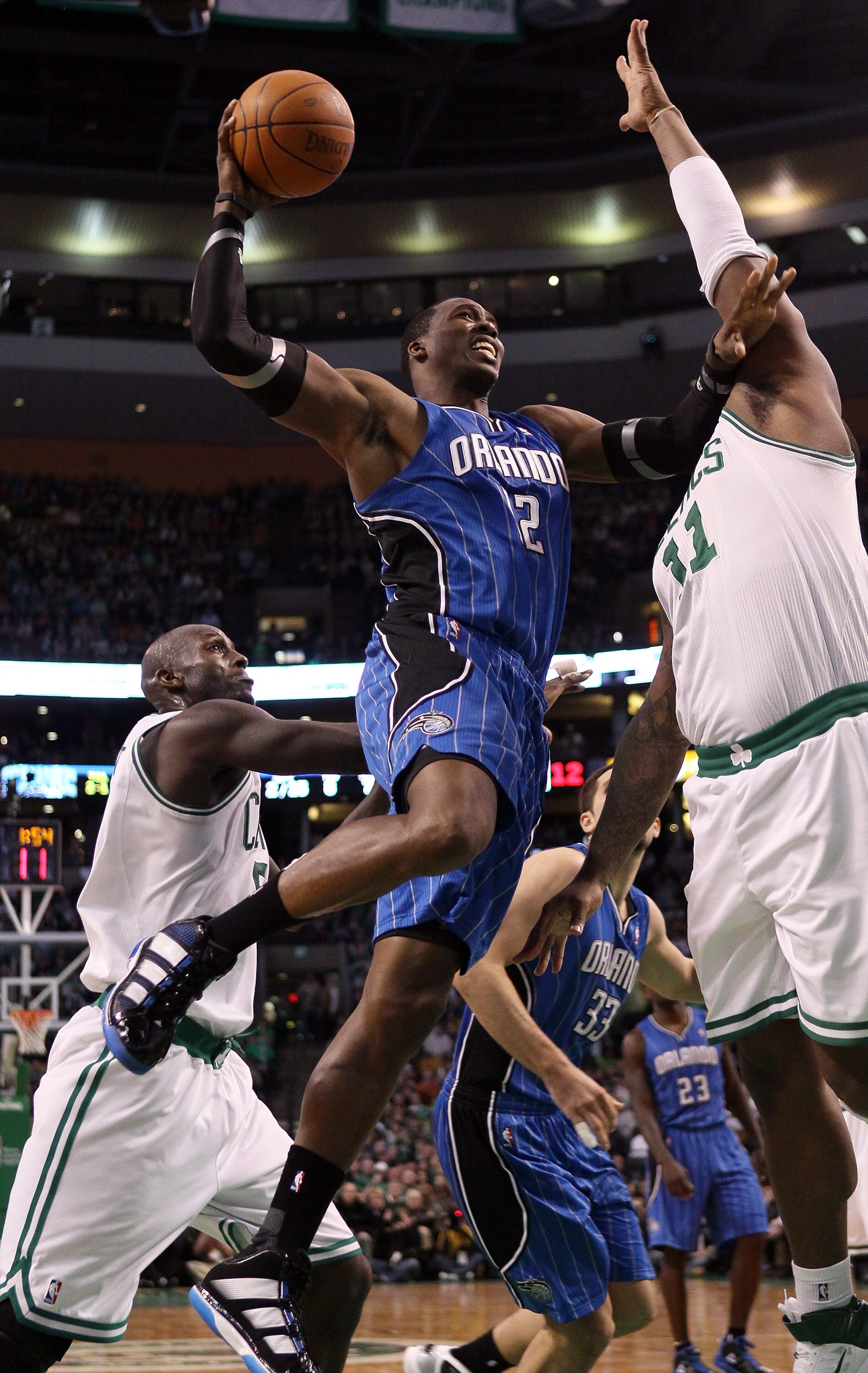 BOSTON, MA - FEBRUARY 06:  Dwight Howard #12 of the Orlando Magic heads for the basket as Kevin Garnett #5 and Glen Davis #11 of the Boston Celtics defend on February 6, 2011 at the TD Garden in Boston, Massachusetts. The Celtics defeated the Magic 91-80.