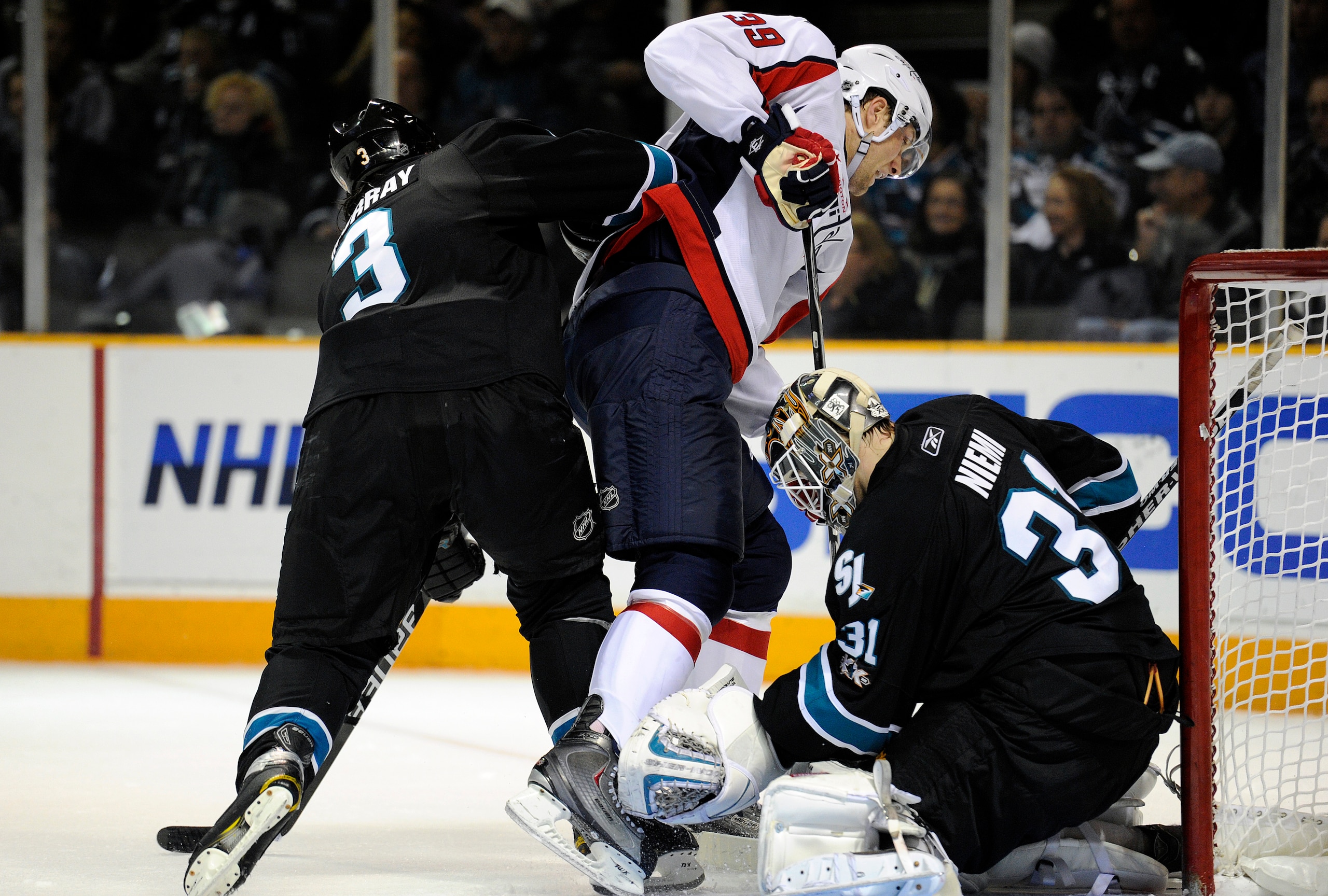 SAN JOSE, CA - FEBRUARY 17: Goalie Antti Niemi #31of the San Jose Sharks  makes a save as David Steckel #39 of the Washington Capitals jumps out of the way of the shot in the third period during an NHL hockey game at the HP Pavilion on February 17, 2011 i